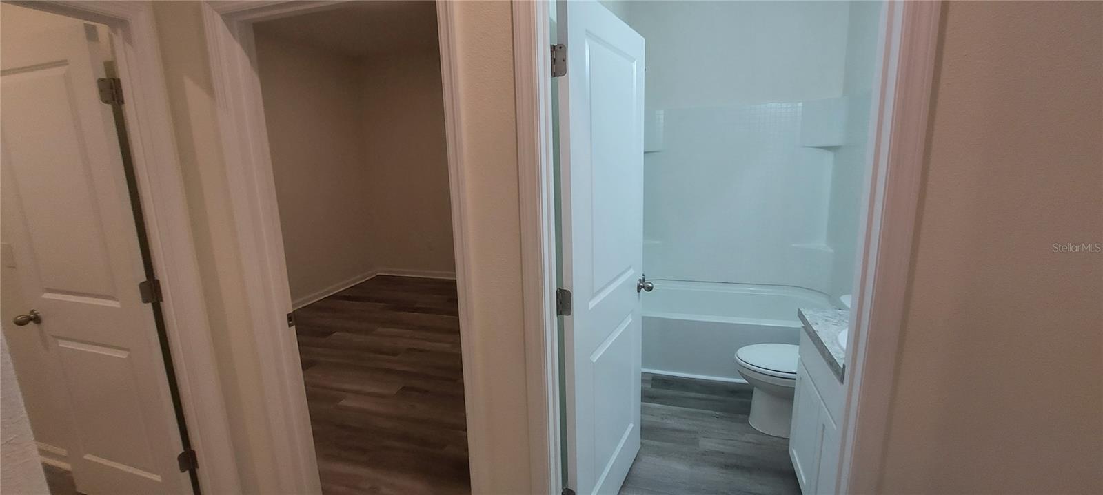 Hallway from garage to bedroom 4, guest bath, and laundry.