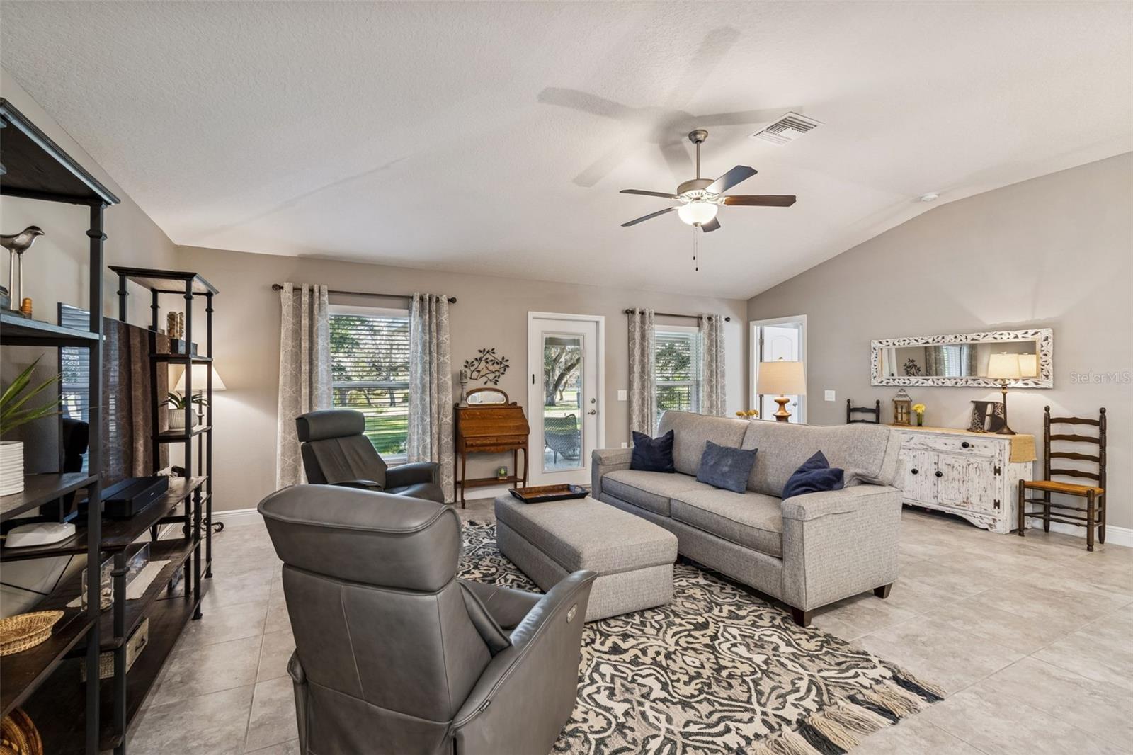 Open Floor Plan with Vaulted Ceilings, 5 1/4 Baseboards, neutral paint throughout home.  Tiled Floors.  Door to the Right leads to the Primary Suite.