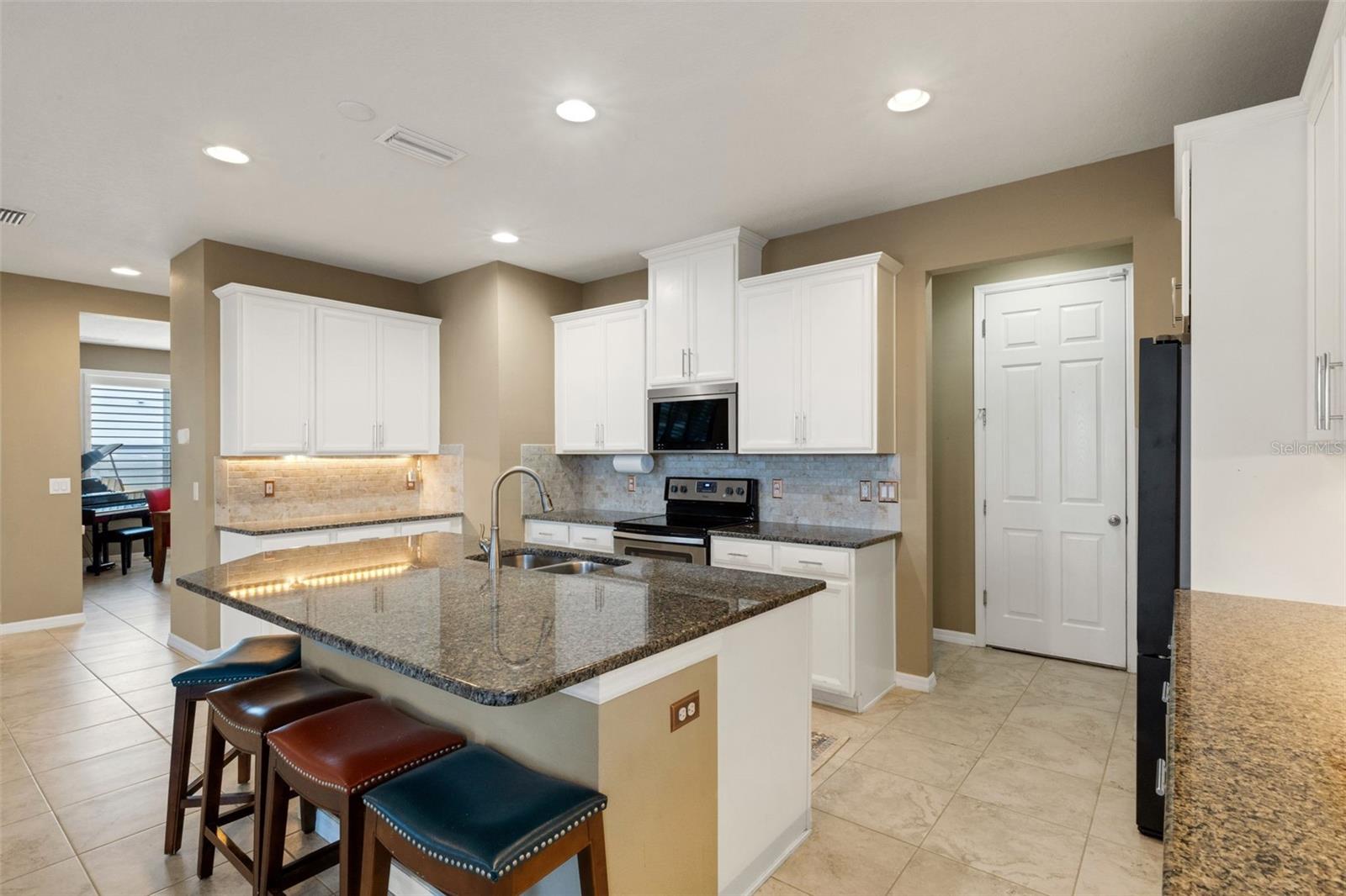 Spacious open kitchen with views of back oasis and pond.