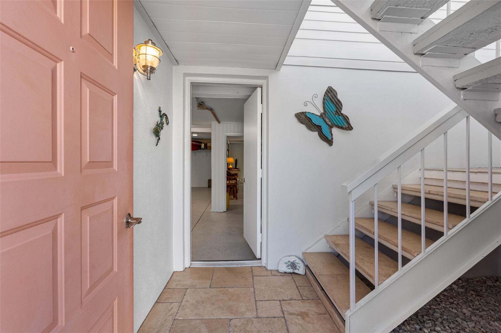 Entry with travertine pavers opens to the lower level and leads to the condo on the upper level.