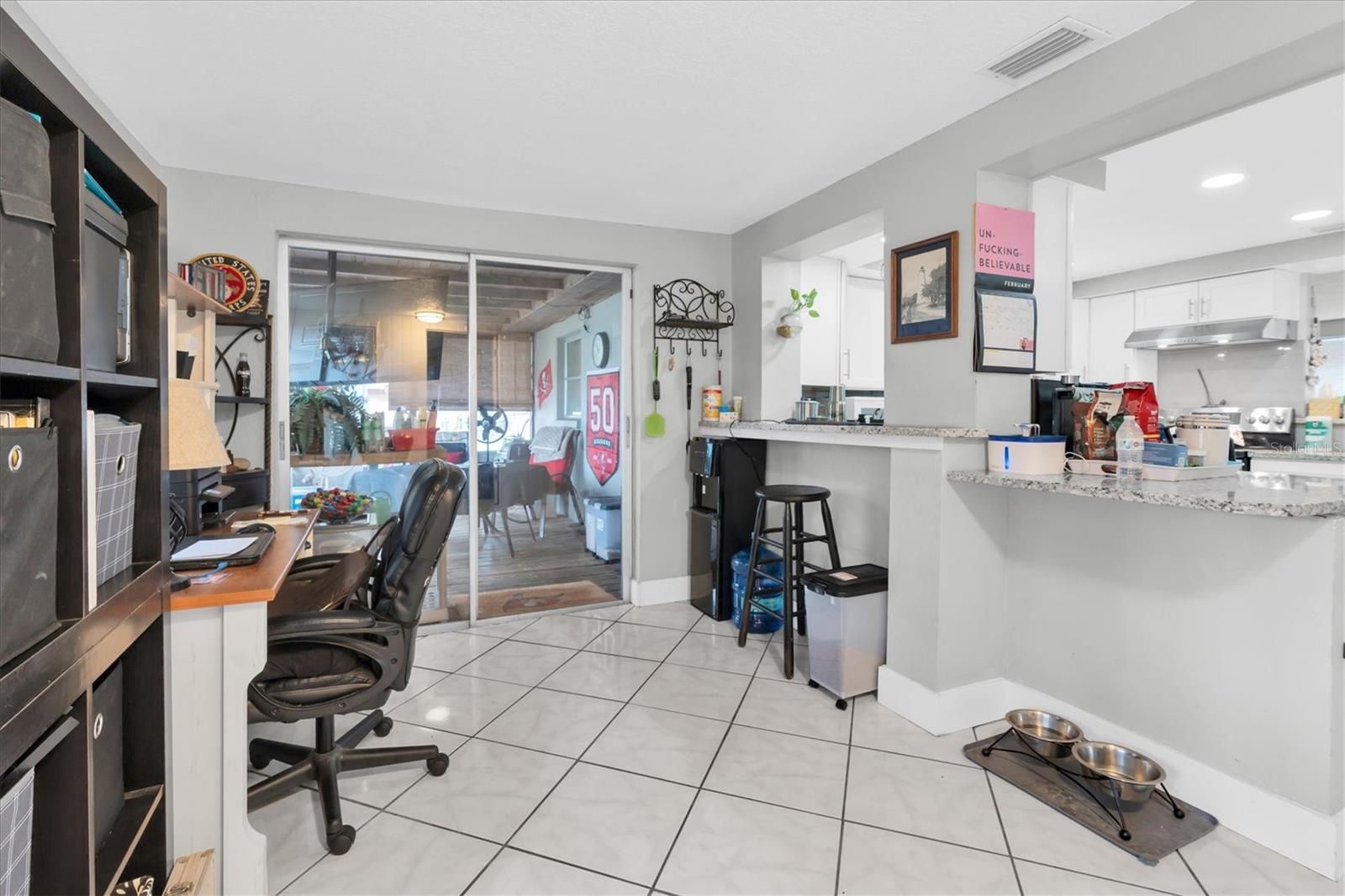Dining room or Florida room adjoining the kitchen. Located on the  back of the home/ lake side of the home.Notice the additional countertop ledge allowing additional seating along the entire wall.