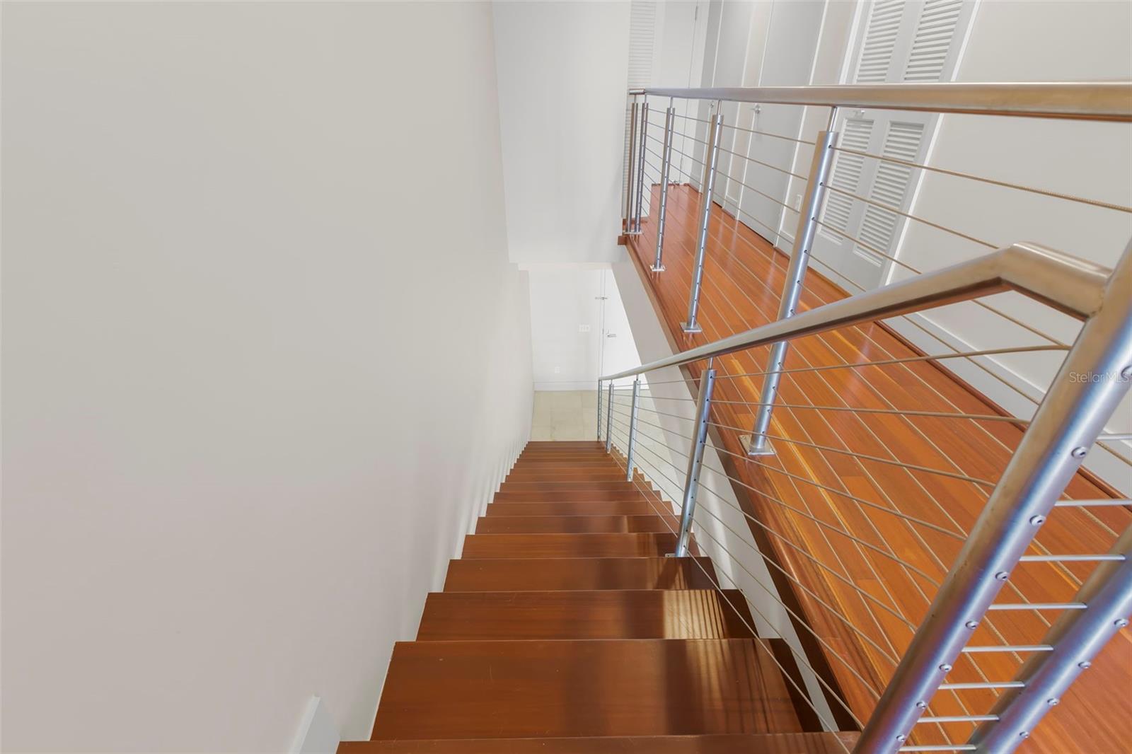 Stairway to upper level housing primary and fourth bedroom or office
