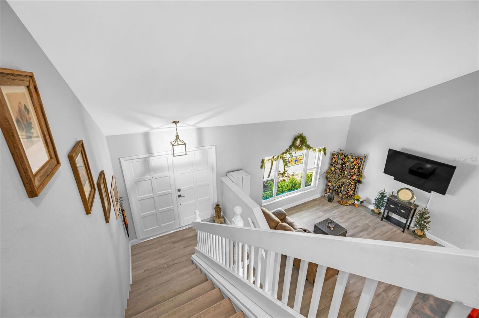 View of the great room and front entry from the top of the stairs