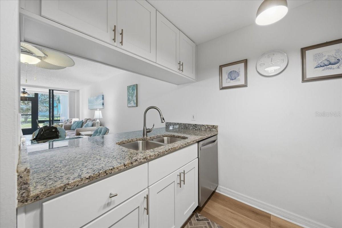 UPDATED KITCHEN with granite countertops, white soft-close cabinets, and stainless-steel Whirlpool appliances.