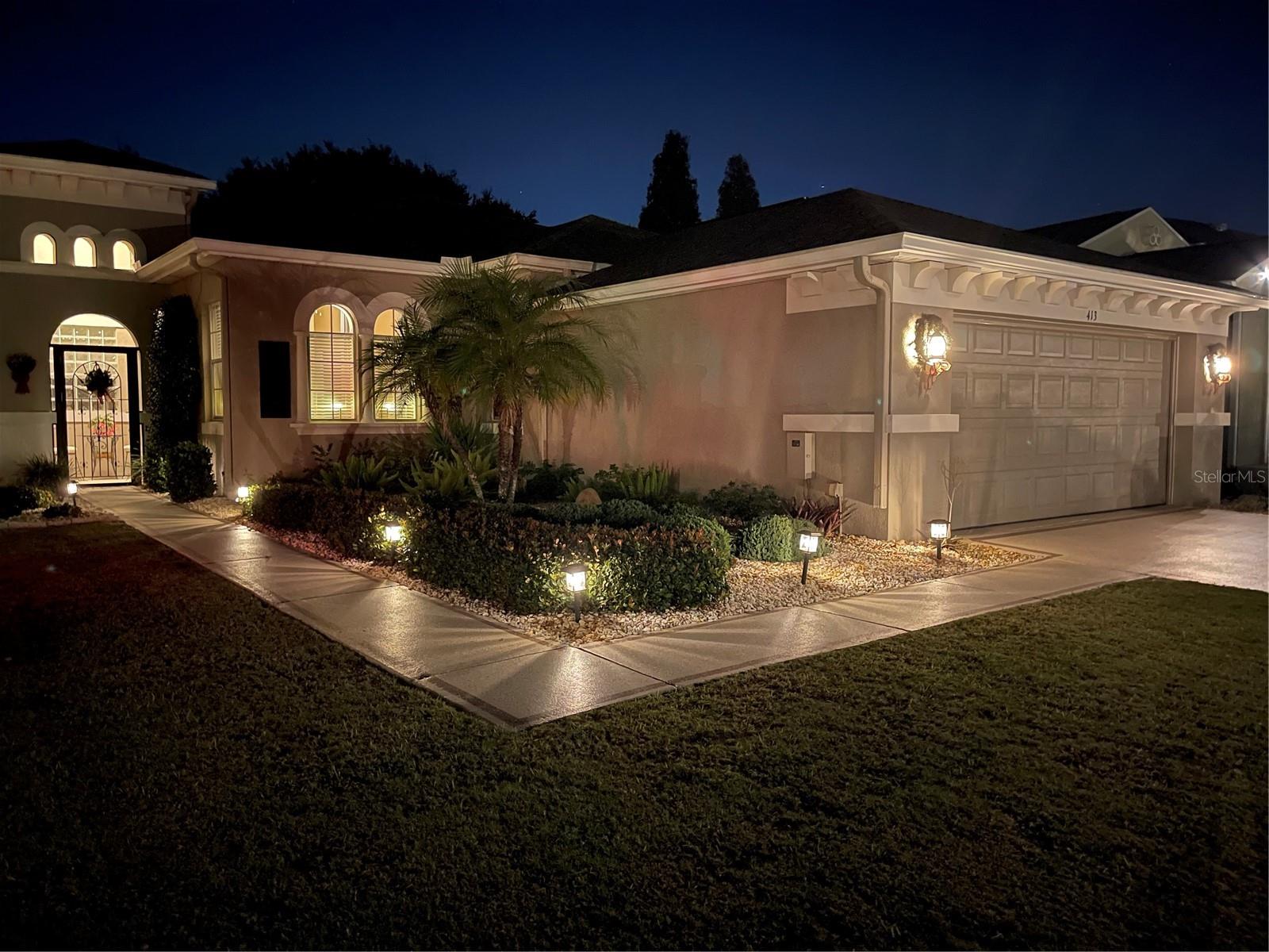 Beautiful outdoor lights accentuate the architecture with easy to maintain landscaping surrounding the home.