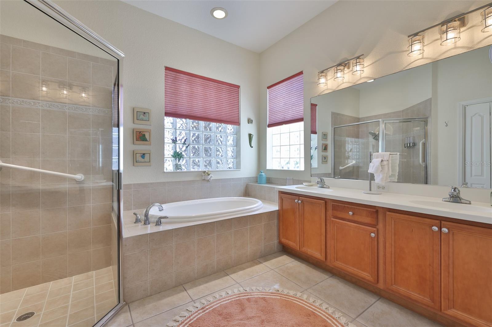 Shower stall and a soaking tub are just the beginning.  Dual sinks, lovely all wood cabinetry and huge privacy glass windows for lots of natural light.