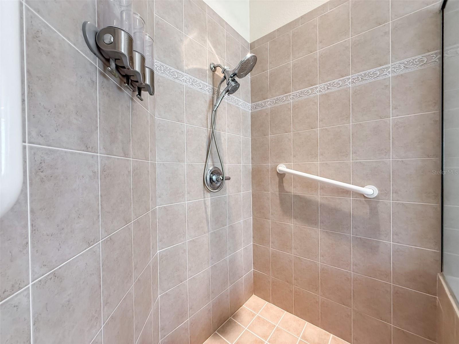 The shower is large, contemporary and beautifully detailed.  Notice the grab bar.