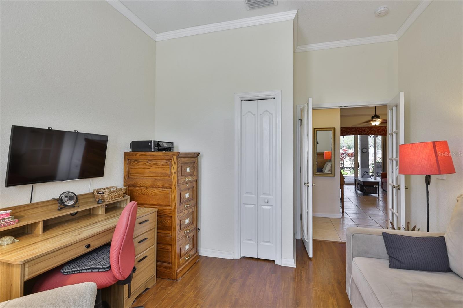 Office, den or third bedroom is good size, with glass paneled doors, crown molding, and a closet.