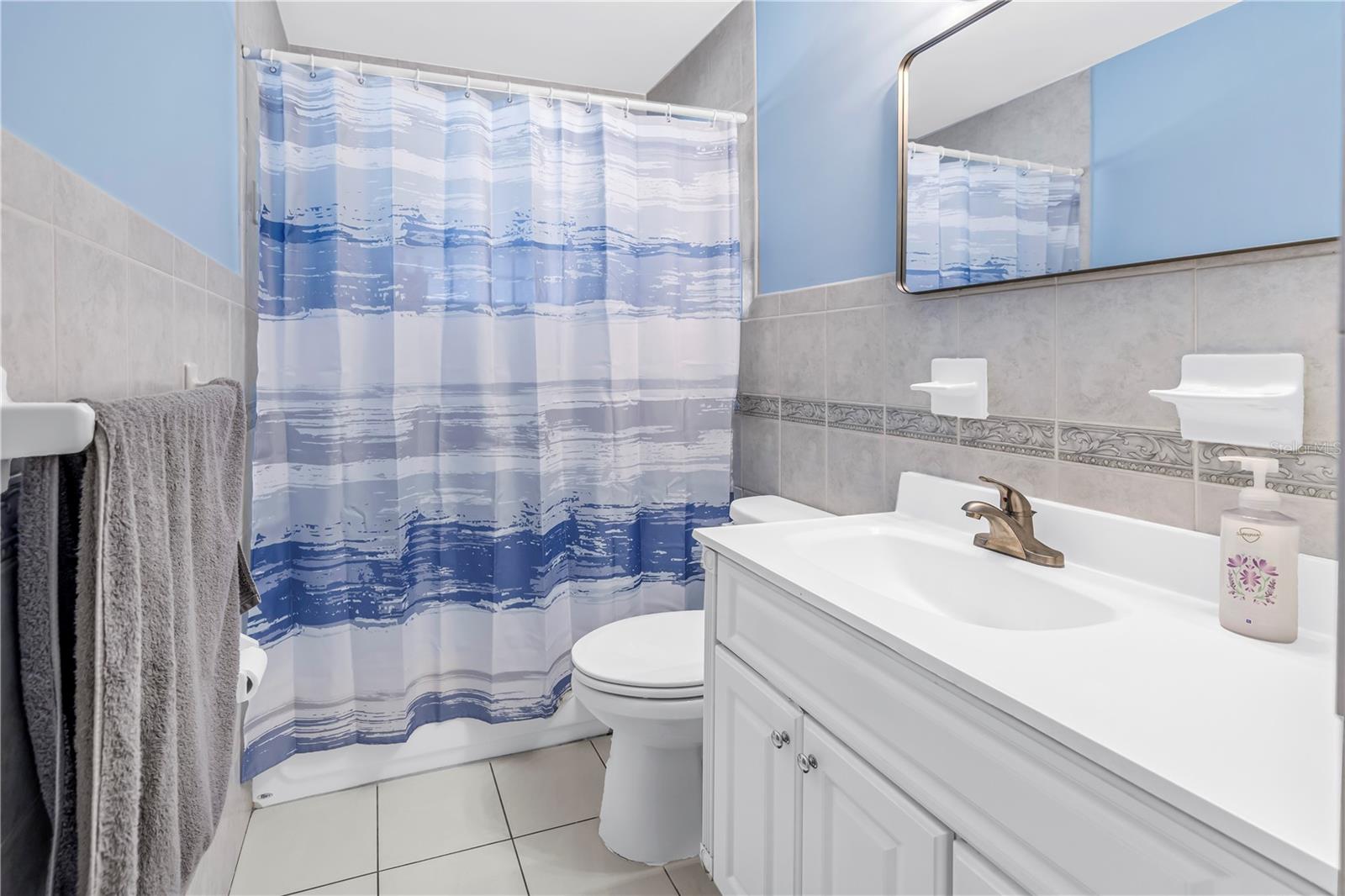 Guest bathroom features a new vanity mirror and fresh paint.