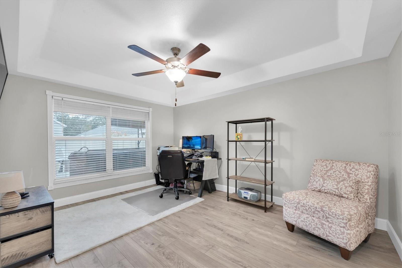 The primary bedroom overlooks the pool in the backyard.