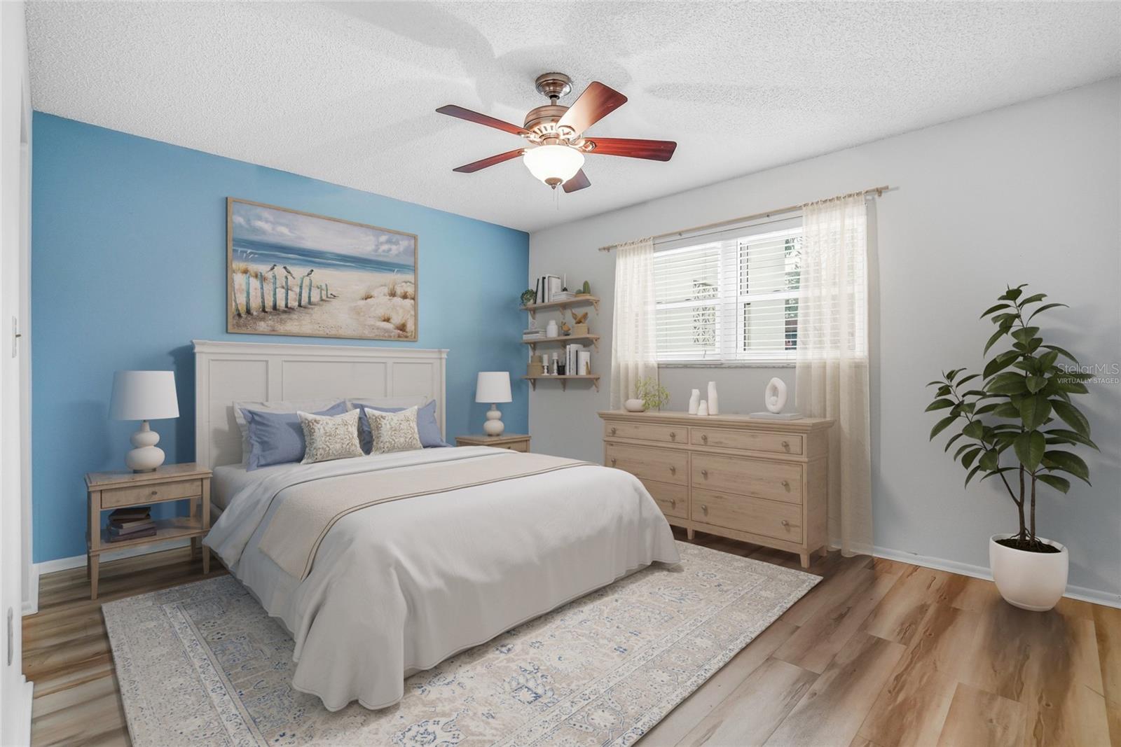 Virtually Staged. Guest bedroom with accent wall, ceiling fan, and roomy proportions.