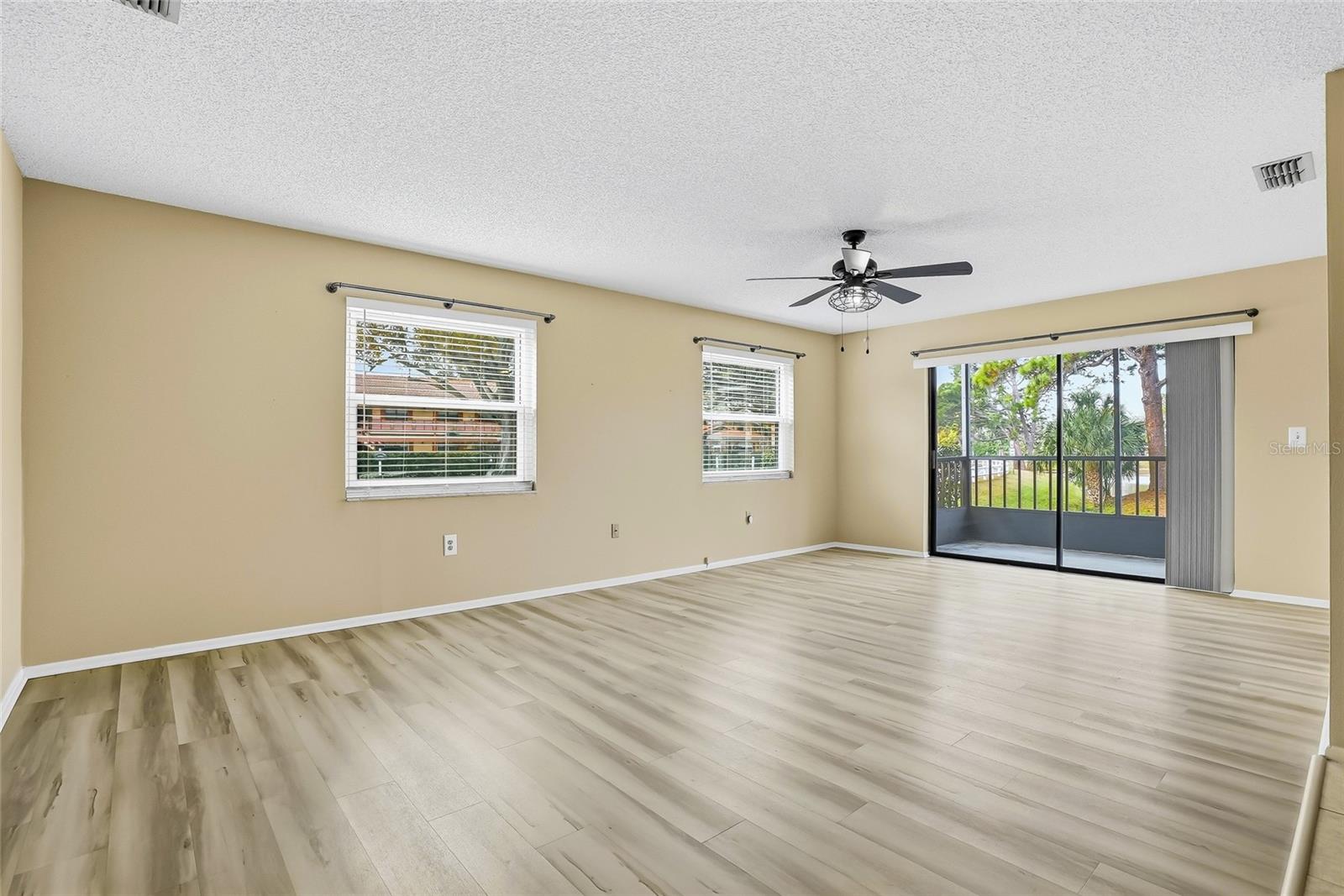 Sun-filled living room with sliders leading to the screened lanai.
