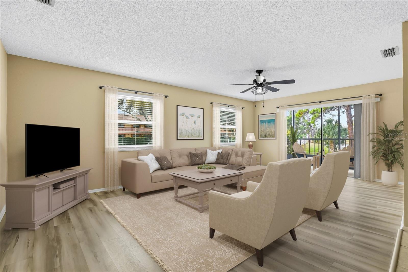 Virtually Staged. Sun-filled living room with sliders leading to the screened lanai.