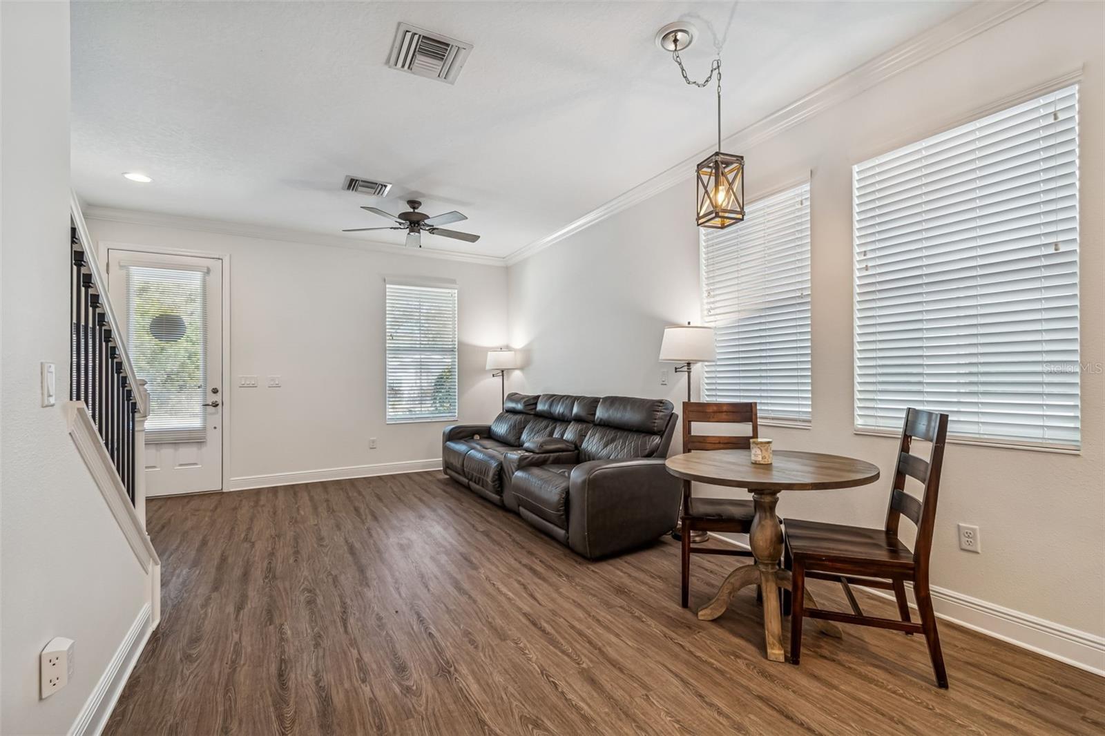 Comfortable and airy living-dining combo, complete with stylish pendant lighting and easy access to the backyard via a rear door.