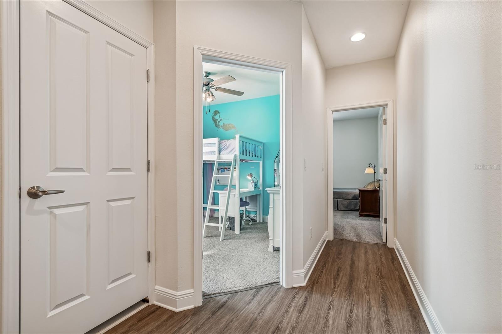 Inviting second-floor hallway with recessed lighting and a clear path to secondary bedrooms.