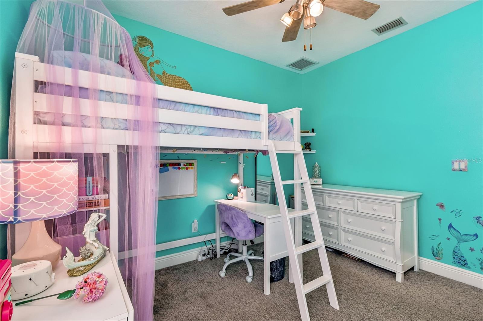 Organized and colorful, this bedroom offers built-in workspace and ample room for creativity or learning.