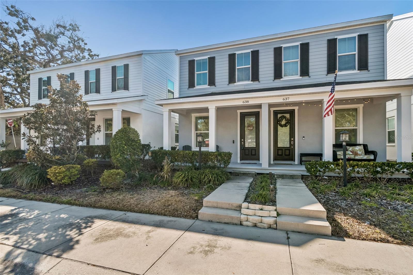 Neighbor-friendly porch with decorative plants and plenty of space for outdoor seating, creating a warm welcome.