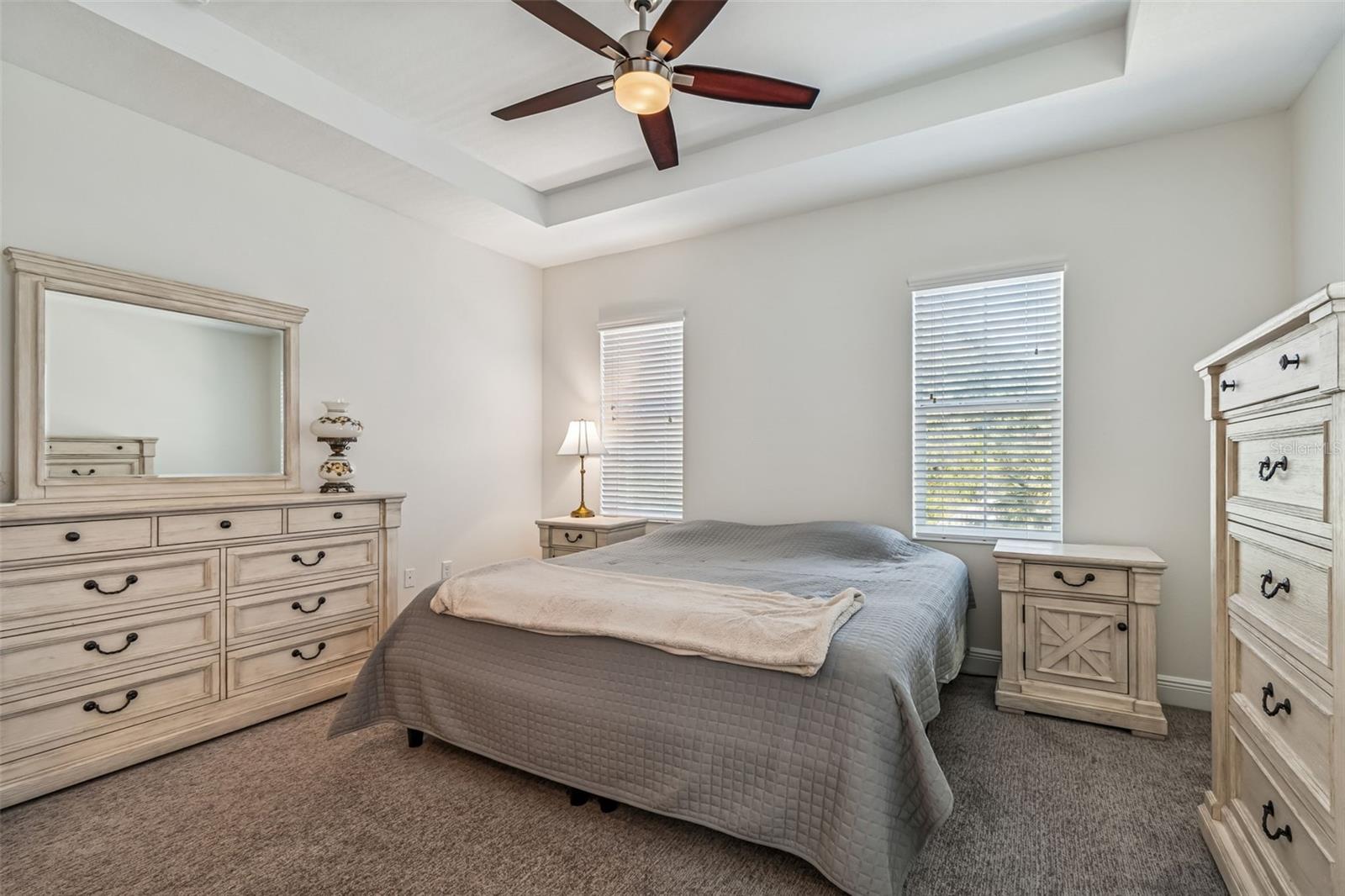 Bright and spacious with tray ceilings, neutral tones, and matching light wood furnishings that offer both charm and functionality.