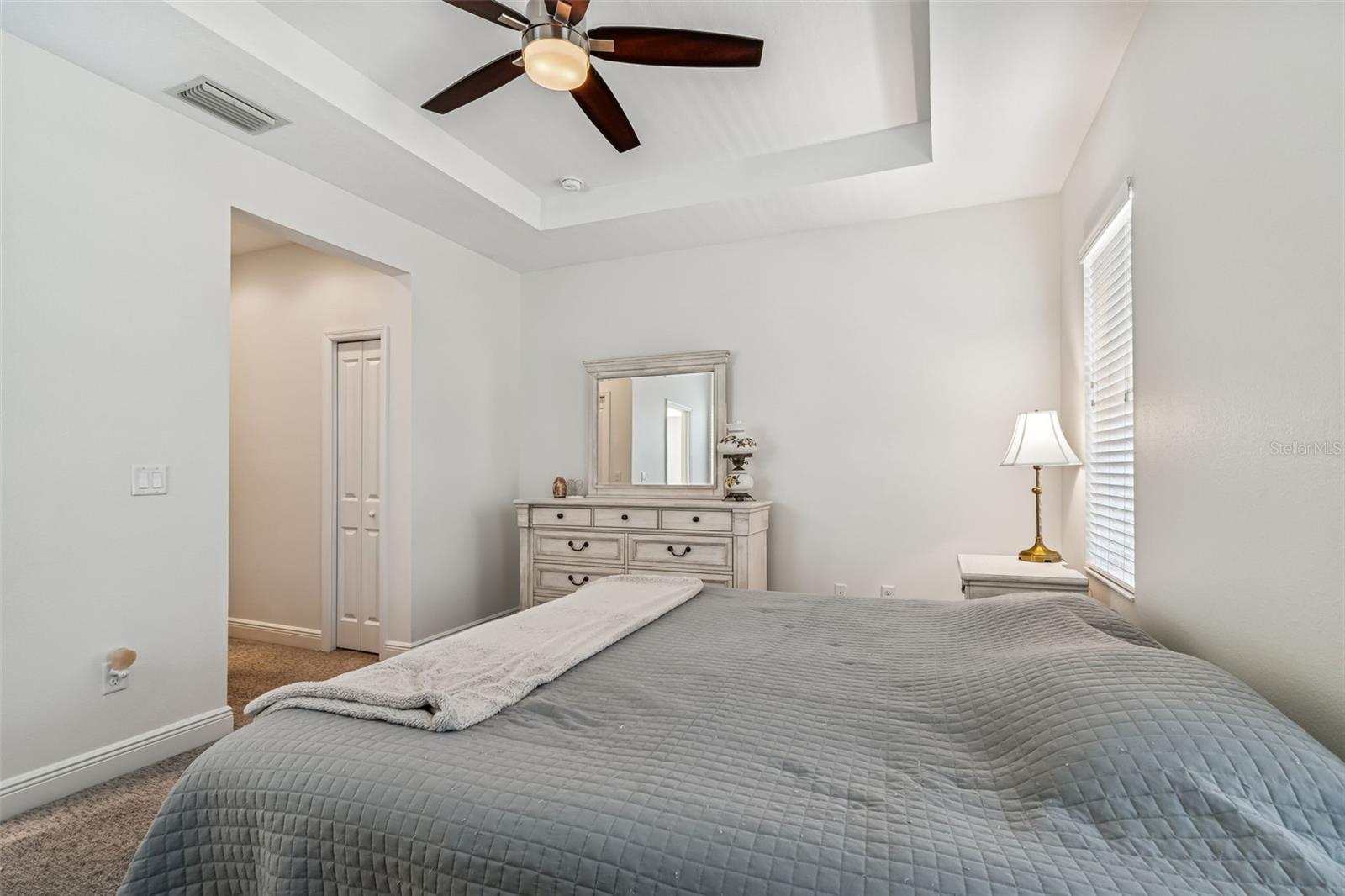 Another perspective highlighting the ceiling fan and private hallway entrance, contributing to the suite's relaxed ambiance.