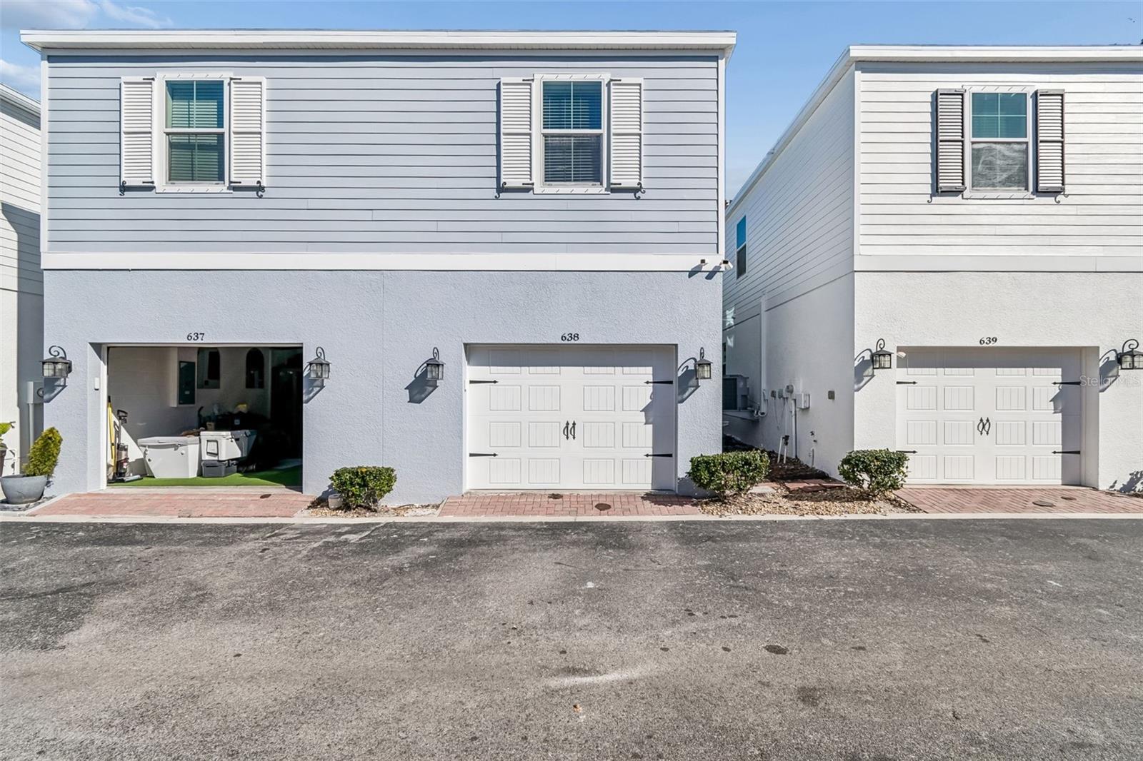 Full view of the home’s rear elevation, showing driveway space and private garage entry in a well-kept townhome community.