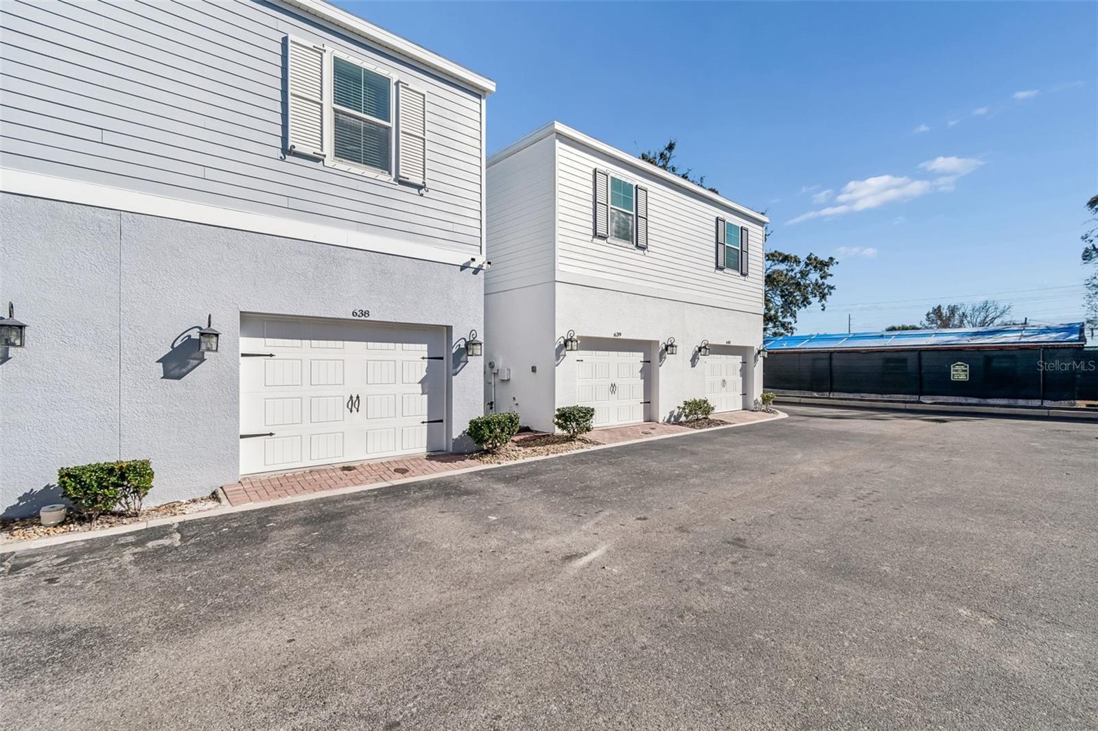 Clean paved access road with attractive, uniform façades and charming shutters—offering a cohesive neighborhood feel.