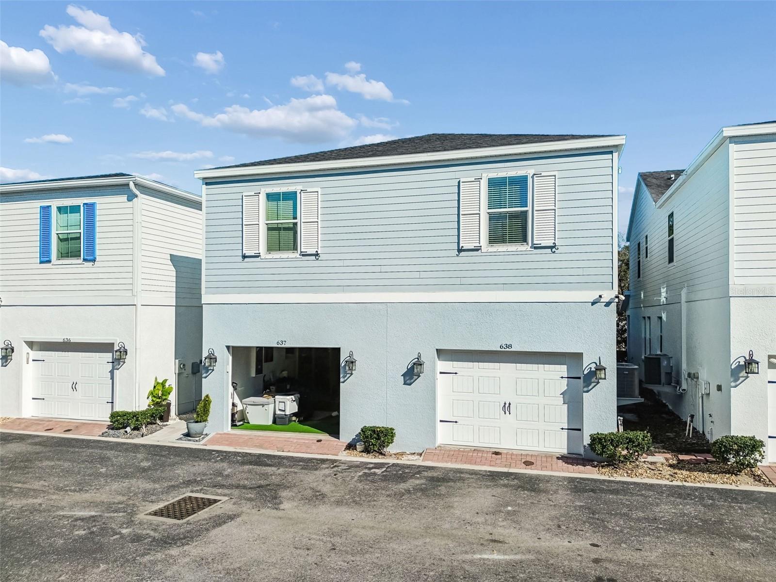 Crisp blue siding and shutter accents define this inviting two-story home, ideally situated within a walkable, newer-build development.