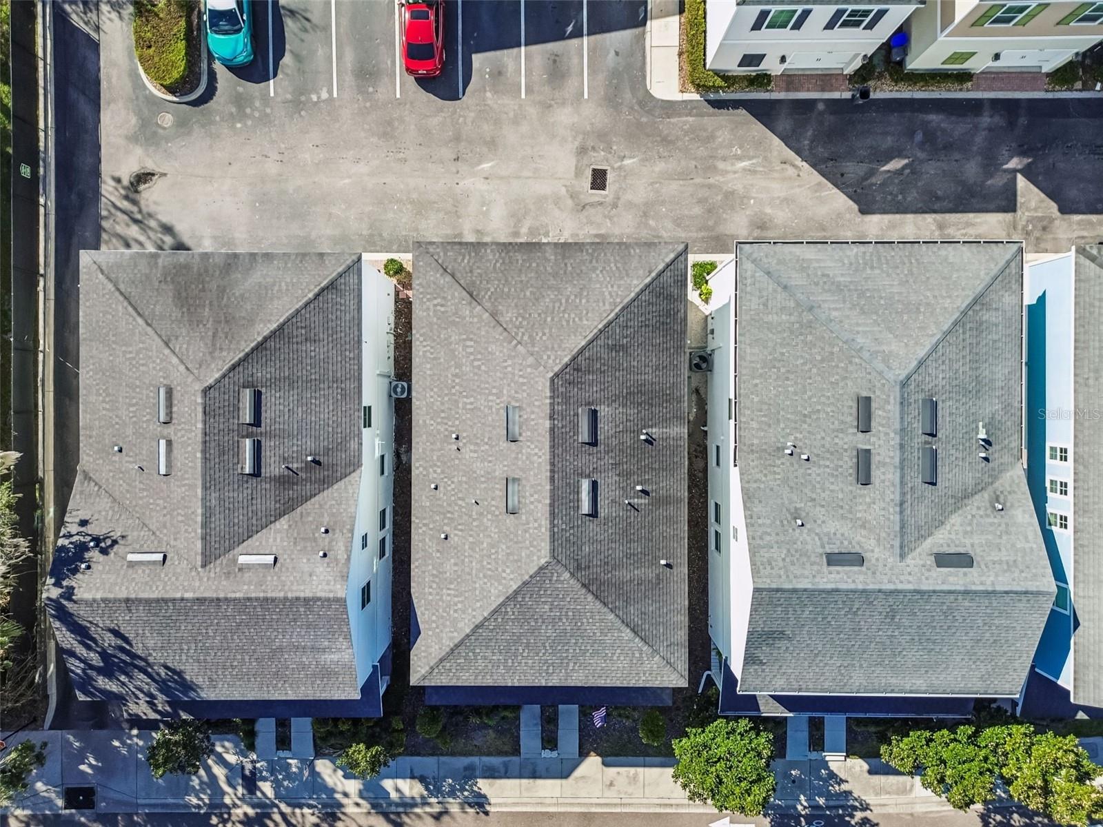 Clean and uniform architectural design across the block, with well-maintained roofs and clear delineation of private driveways.