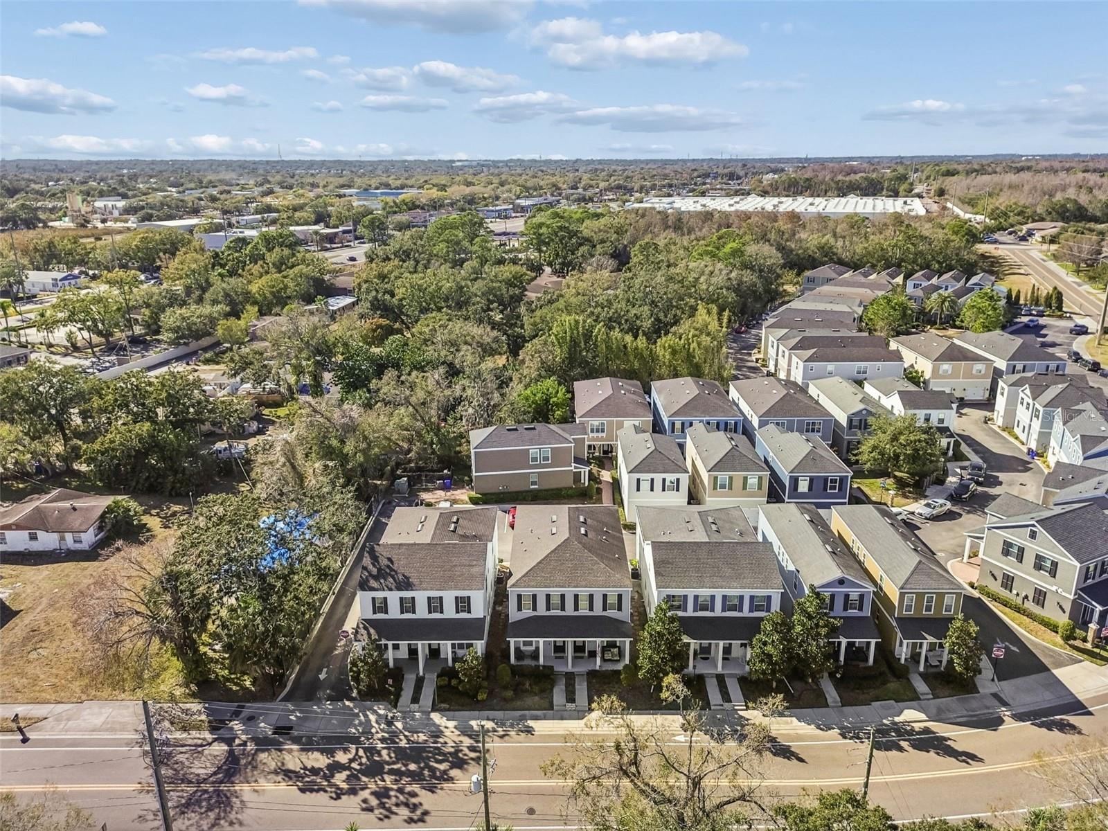 A bird’s-eye view highlights the organized layout of this charming townhome community nestled among mature trees.