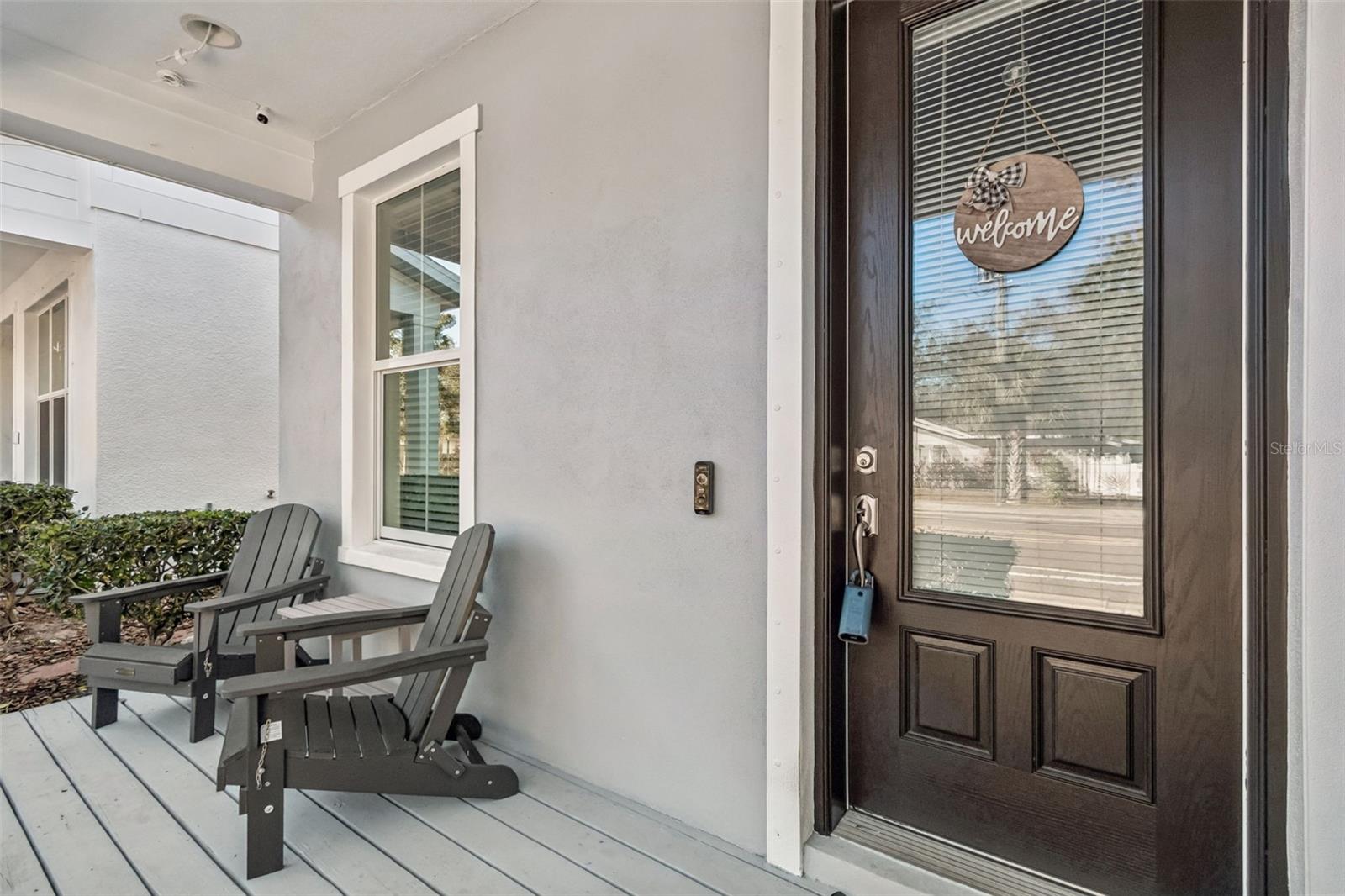 Covered porch with Adirondack chairs and clean composite decking—perfect for relaxing outdoors year-round.