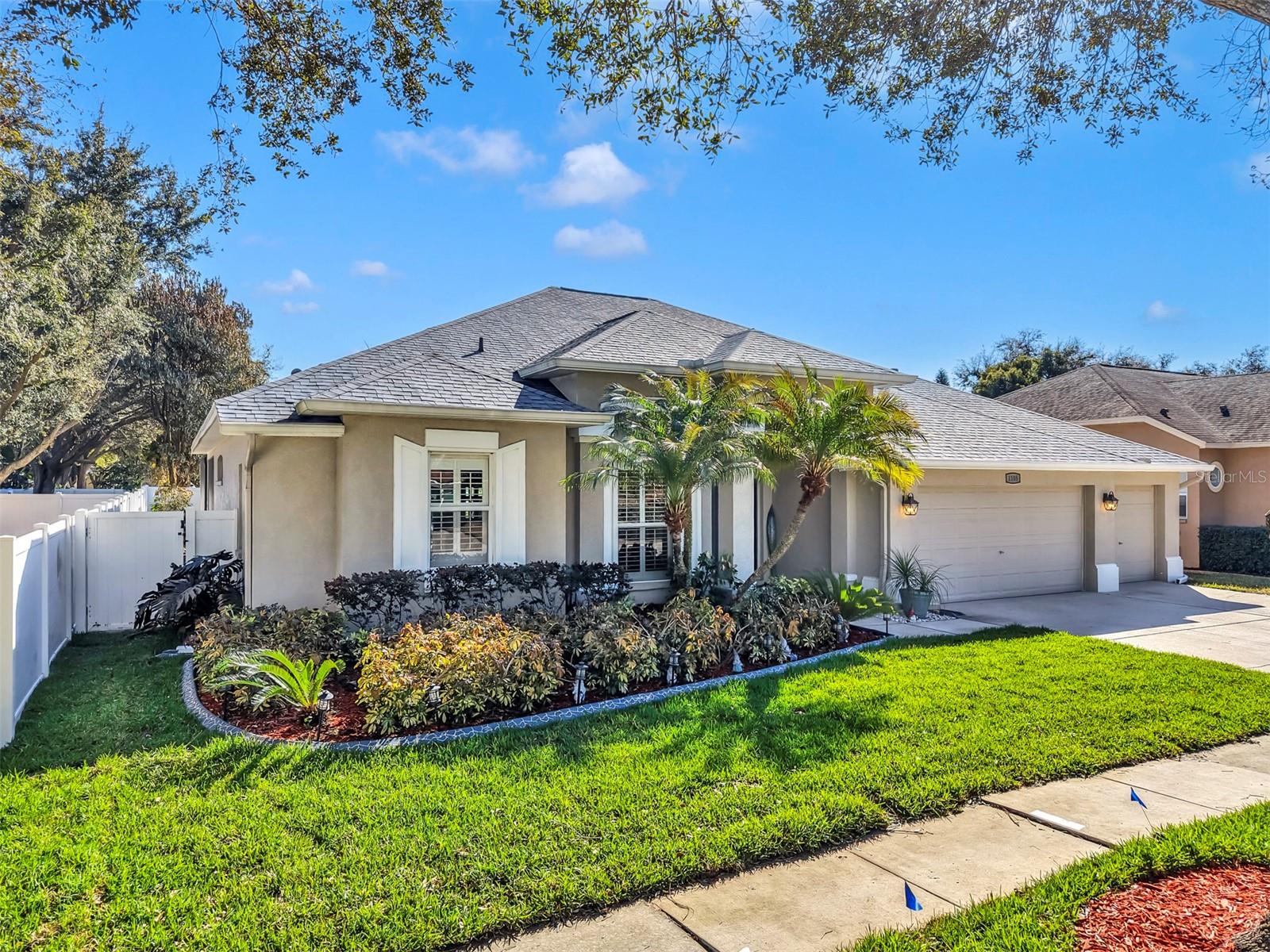 Welcome home—picture-perfect curb appeal with lush landscaping and a charming covered entry.