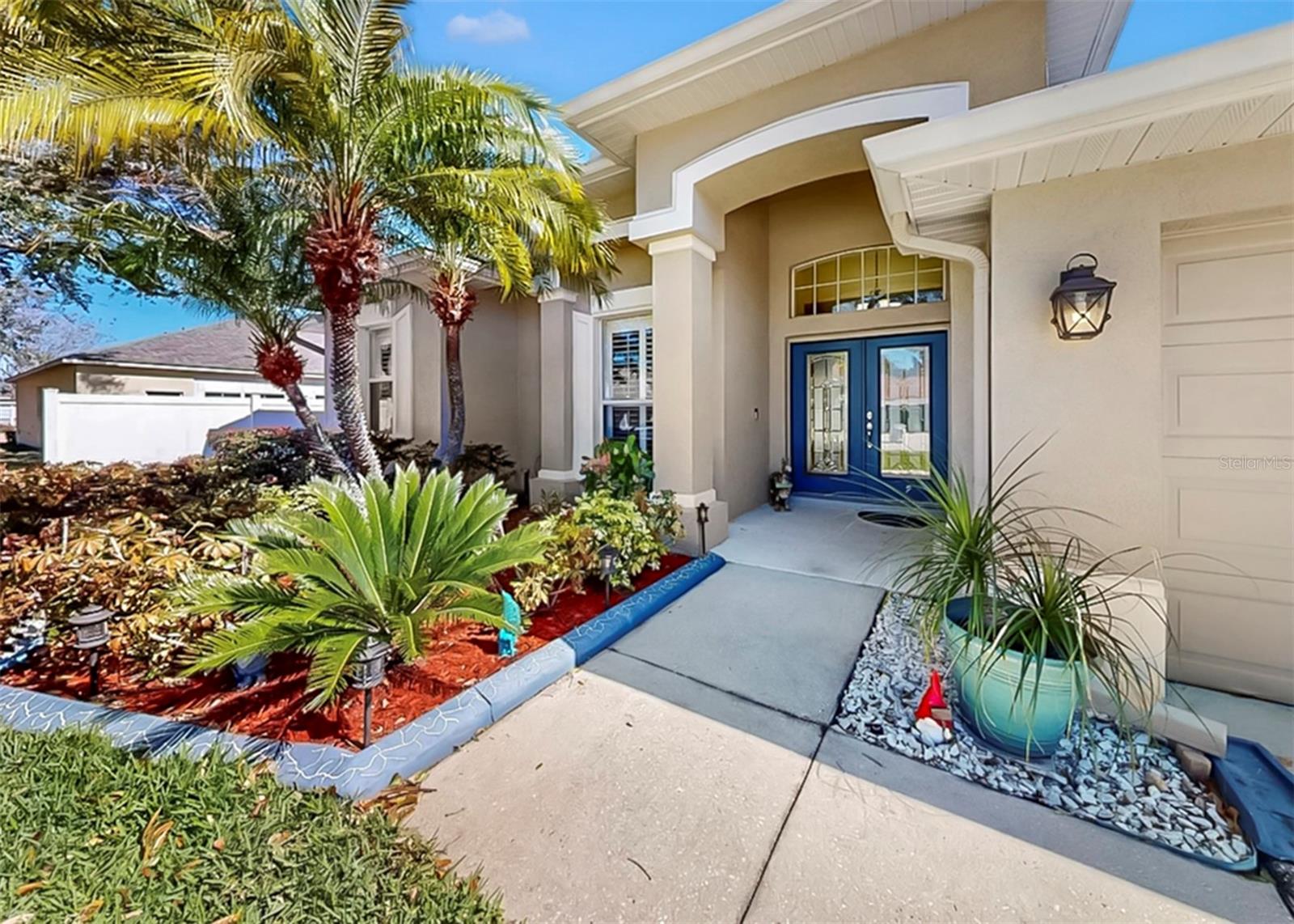Welcome home—picture-perfect curb appeal with lush landscaping and a charming covered entry.