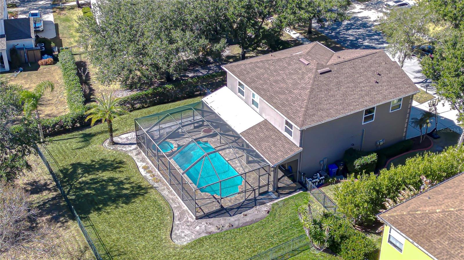 Private, fully fenced  backyard retreat with screened lanai, sparkling pool, and generous green space for outdoor living!