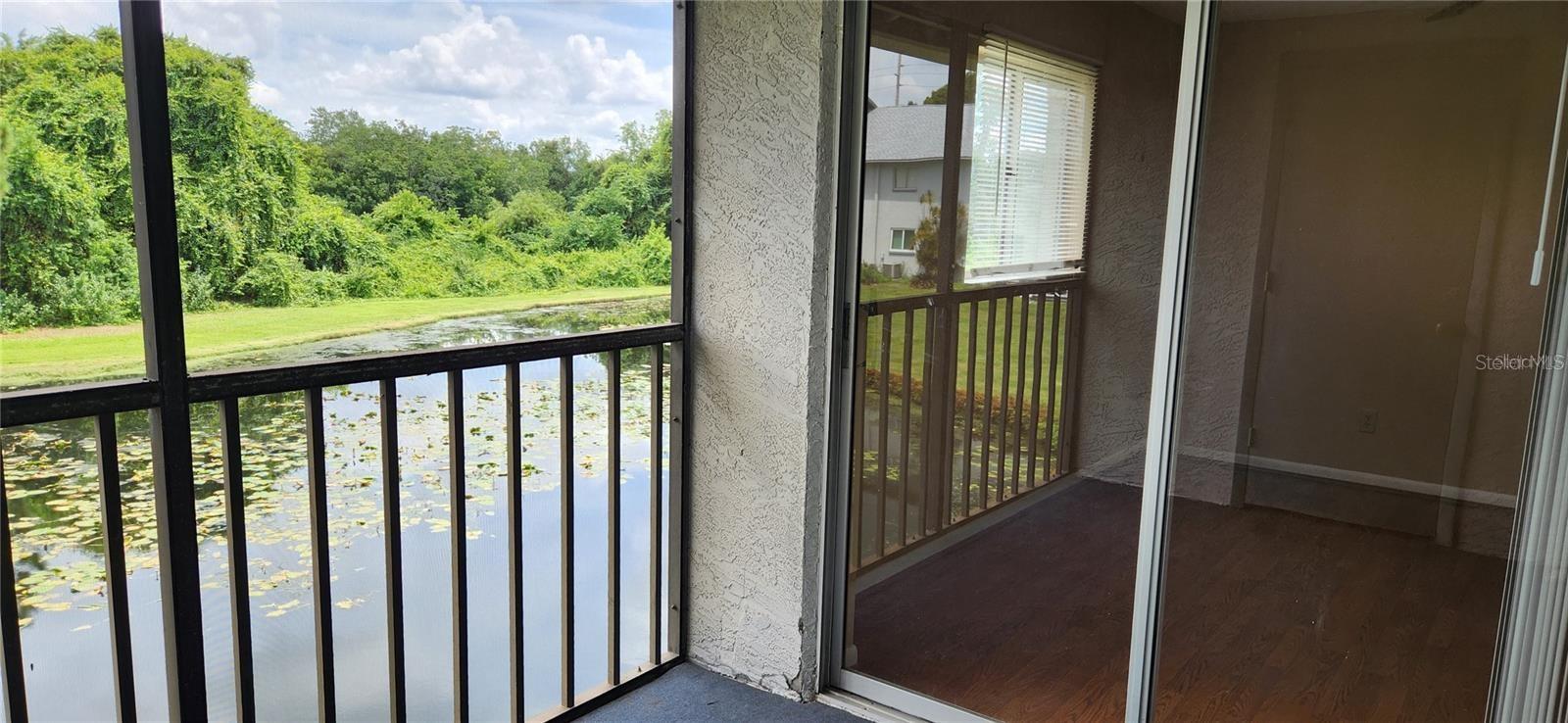 Living room balcony with sliding glass door leading into the primary bedroom