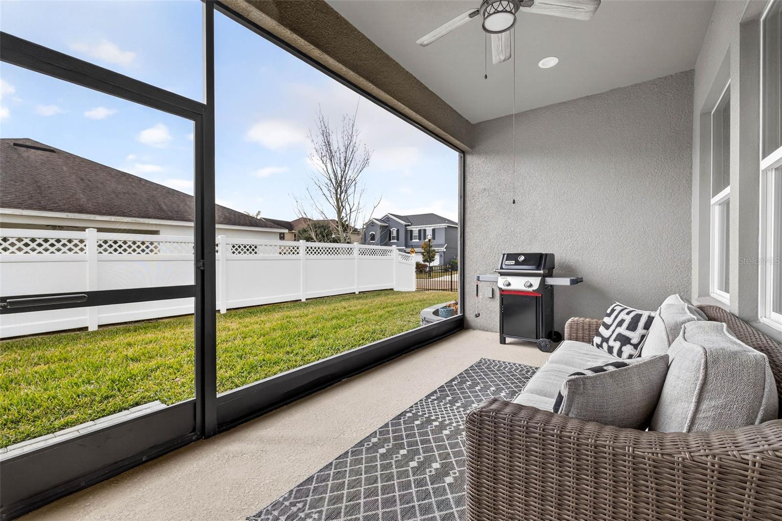 Screened lanai overlooking the fenced yard.