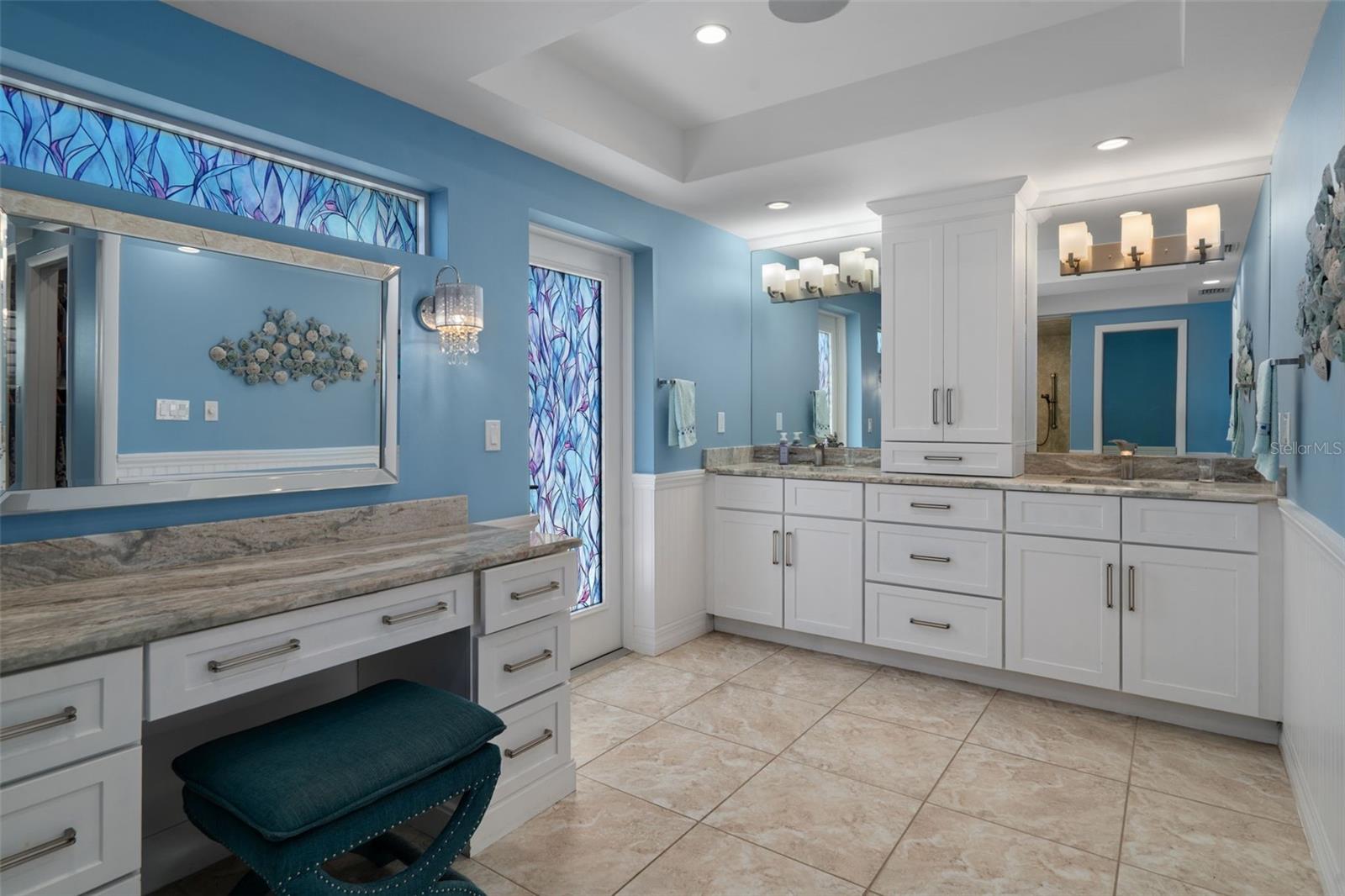 Primary bathroom with dual vanities.