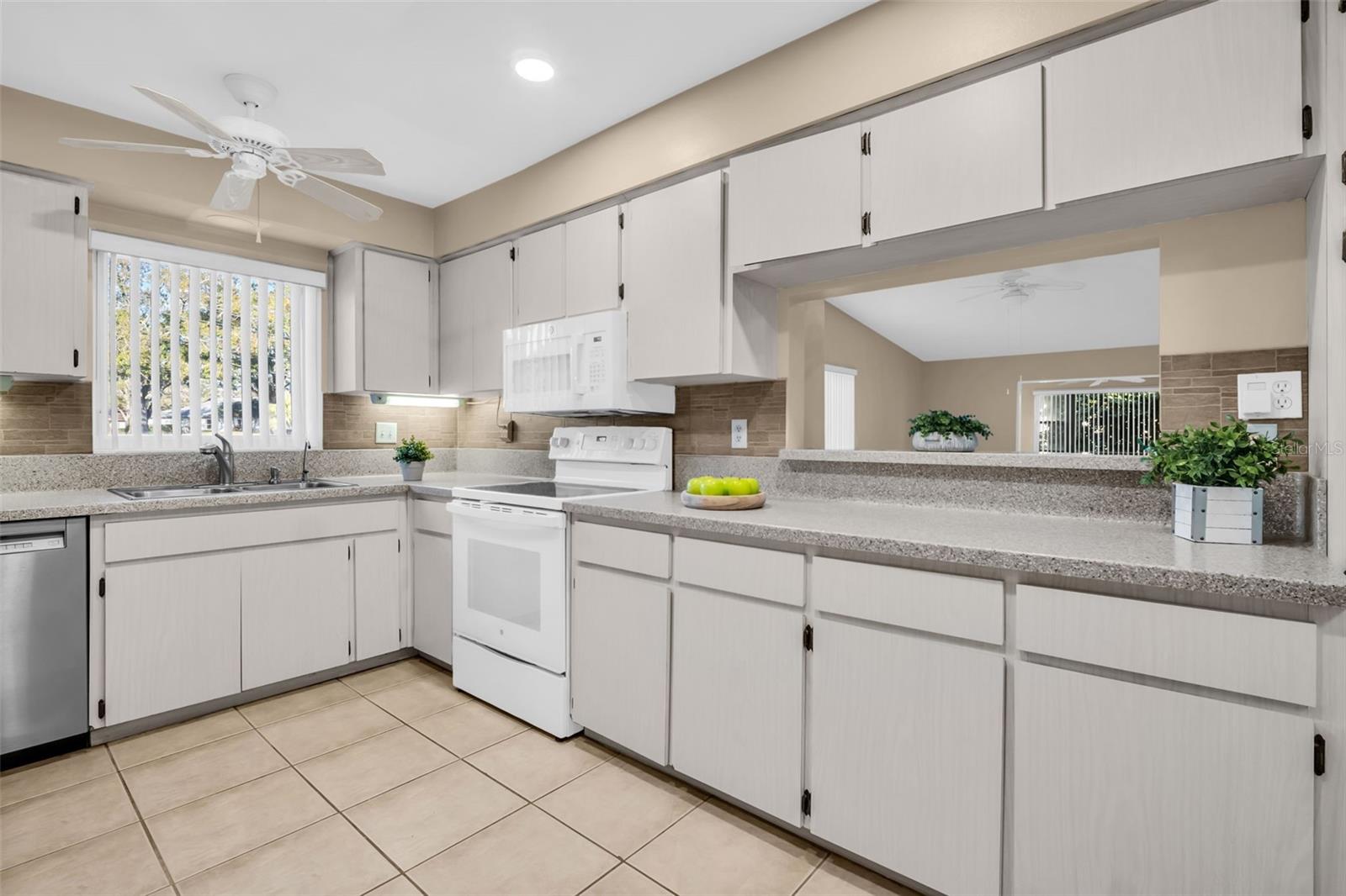 Large kitchen with abundant cabinet and counter space plus a pass-through to the main living~