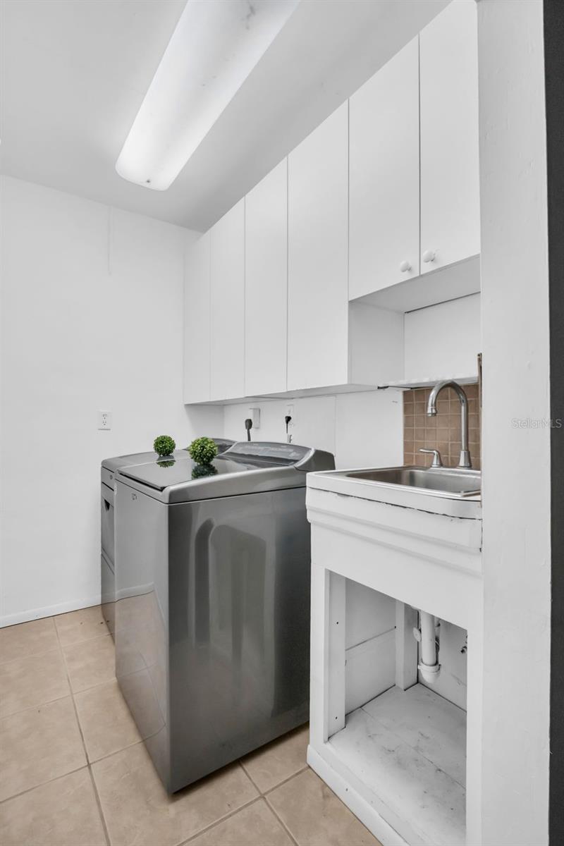 Private laundry room with additional storage and utility sink~