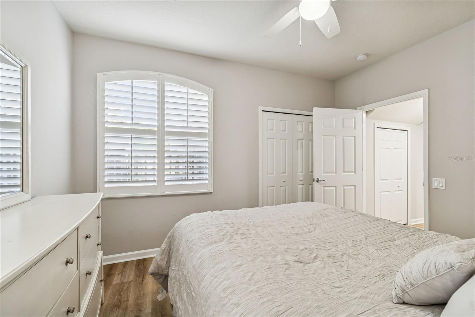 The arched window adds charm and natural light to this inviting space, complemented by ample closet storage.