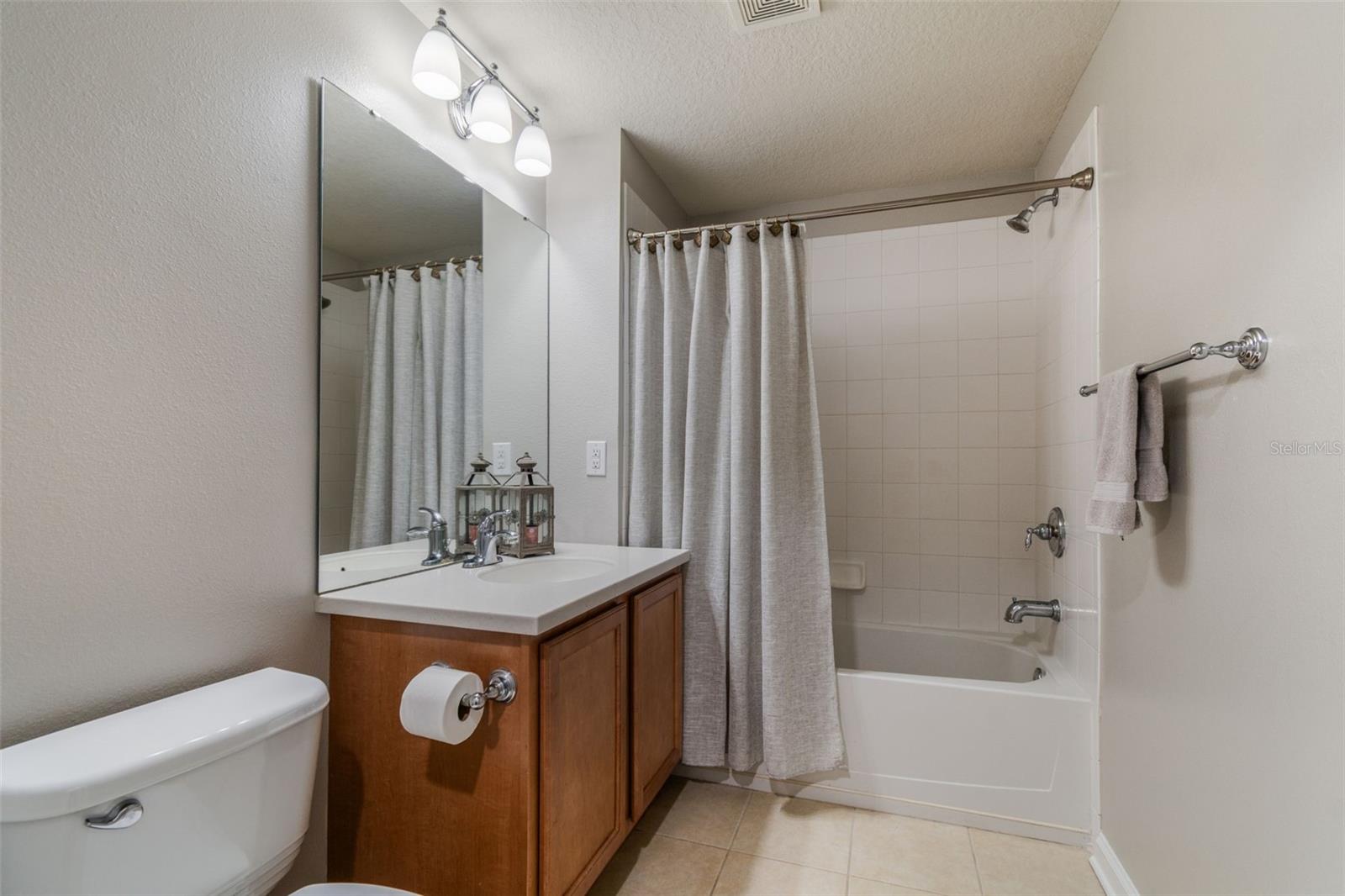 Tiled tub surround and soft finishes give this guest bath a timeless and practical design.