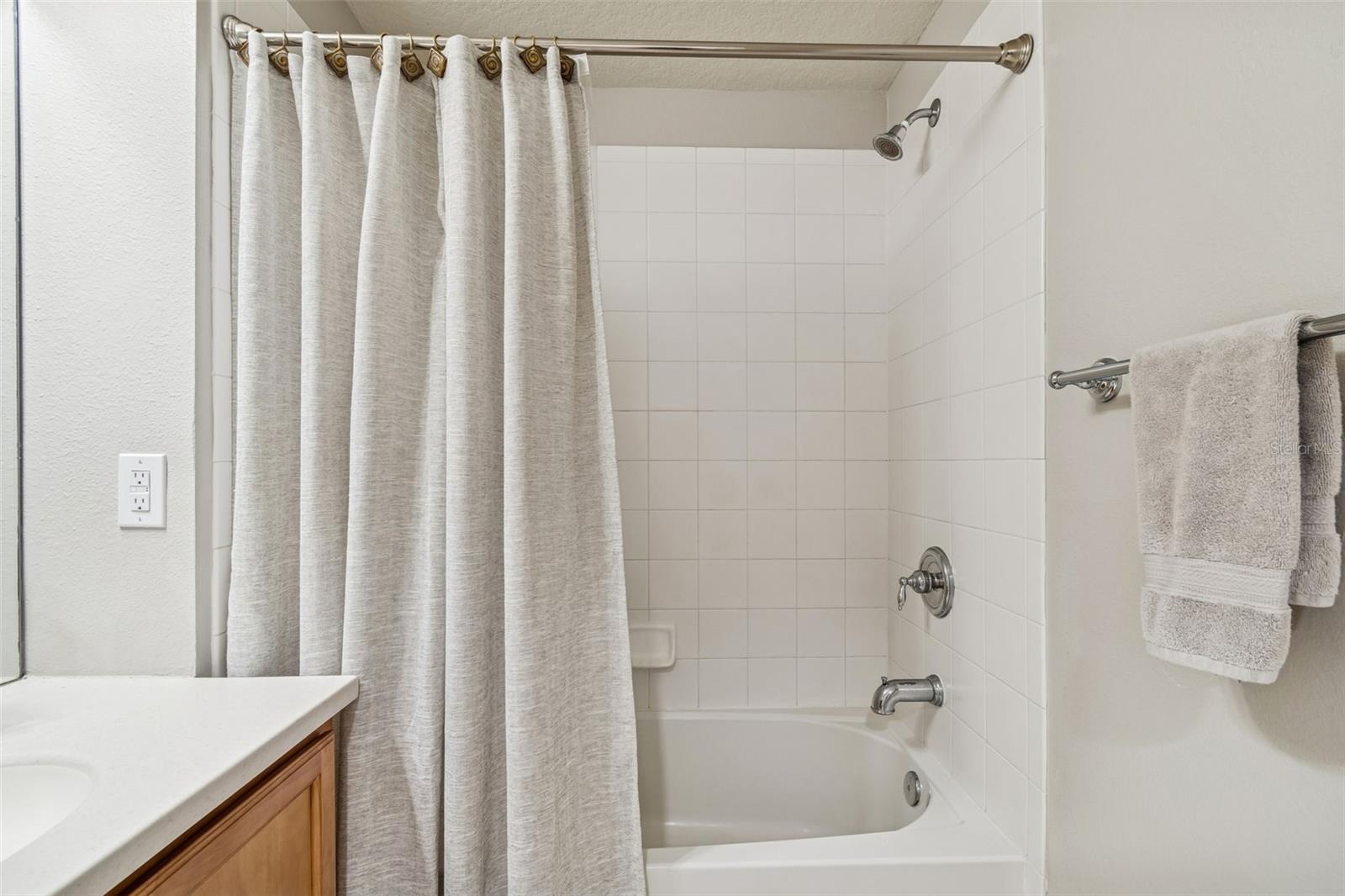 White tile surrounds and brushed nickel fixtures bring a crisp, functional style to the bathroom.