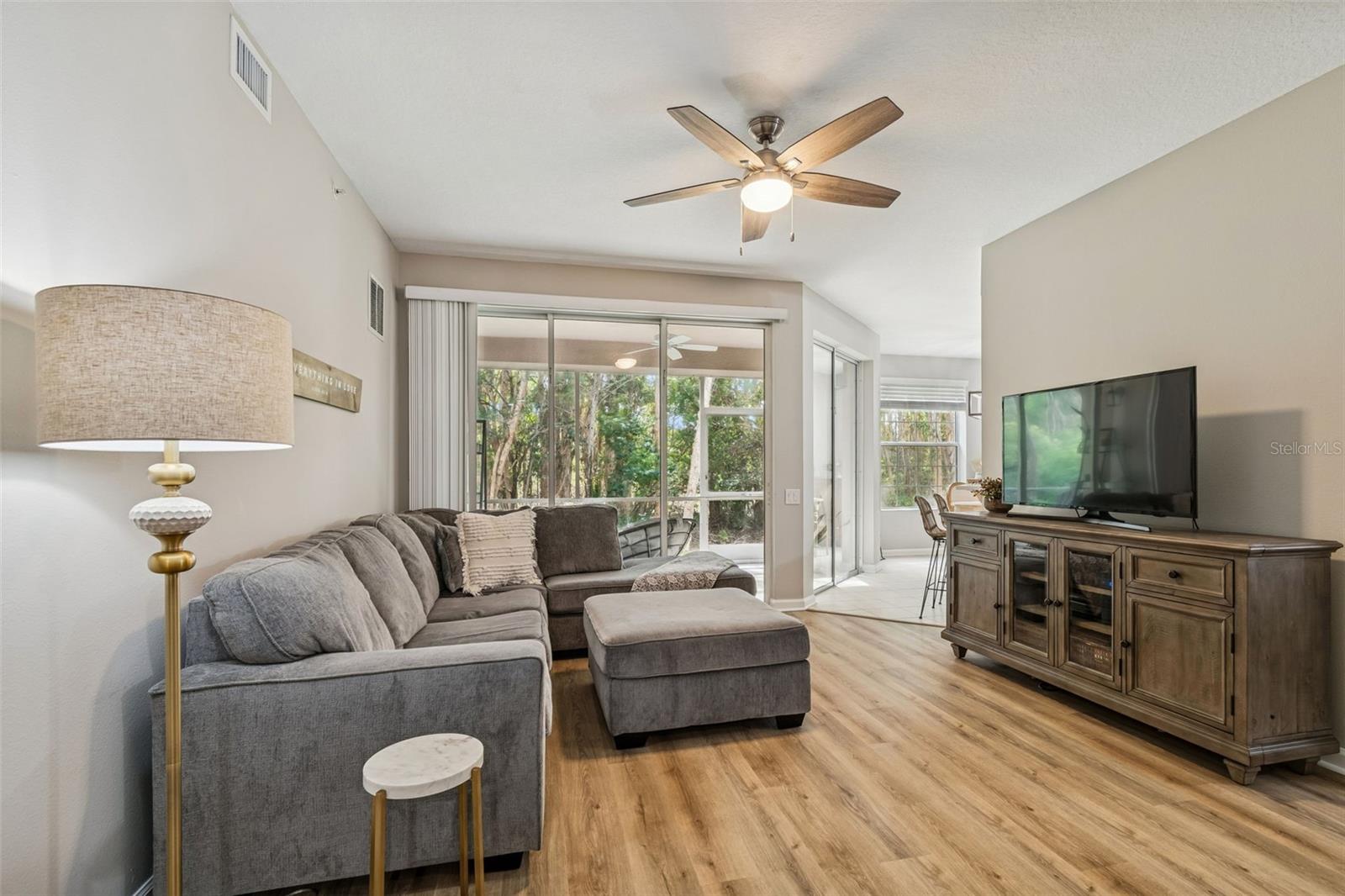 The spacious living area flows seamlessly to the sunroom and outdoor space, ideal for indoor-outdoor Florida living.