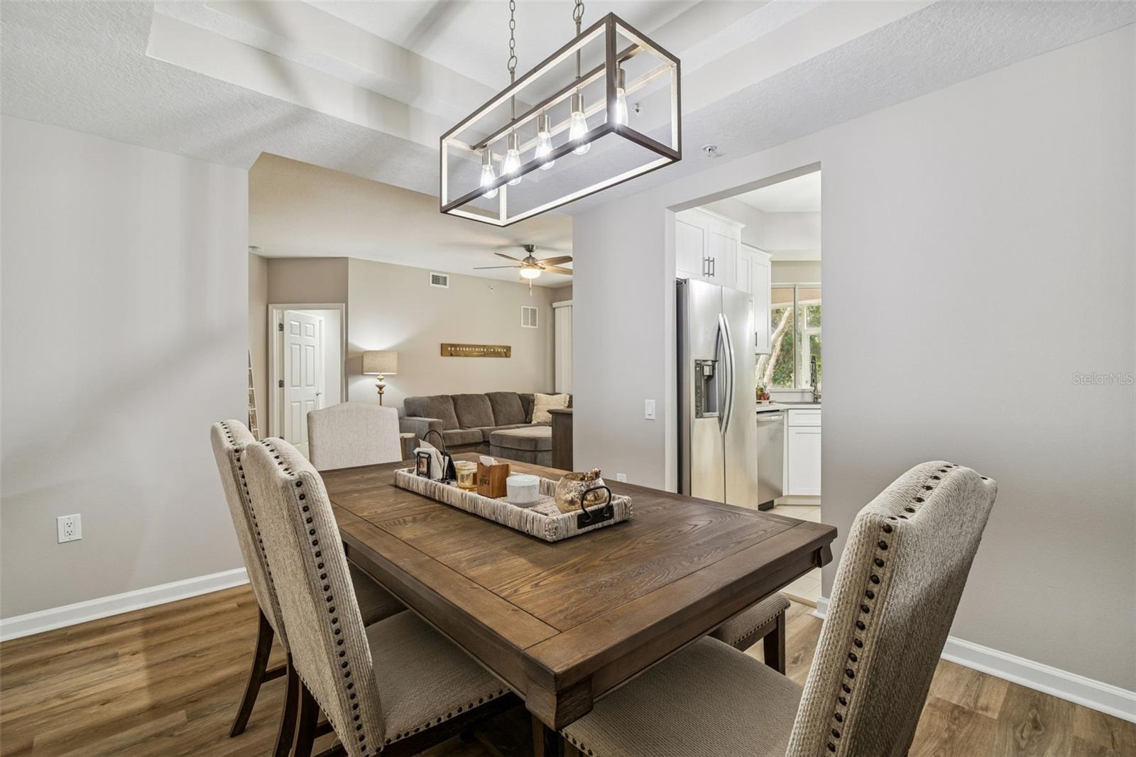 Transitional view from the formal dining space into the kitchen and living room, showcasing open flow and modern finishes.