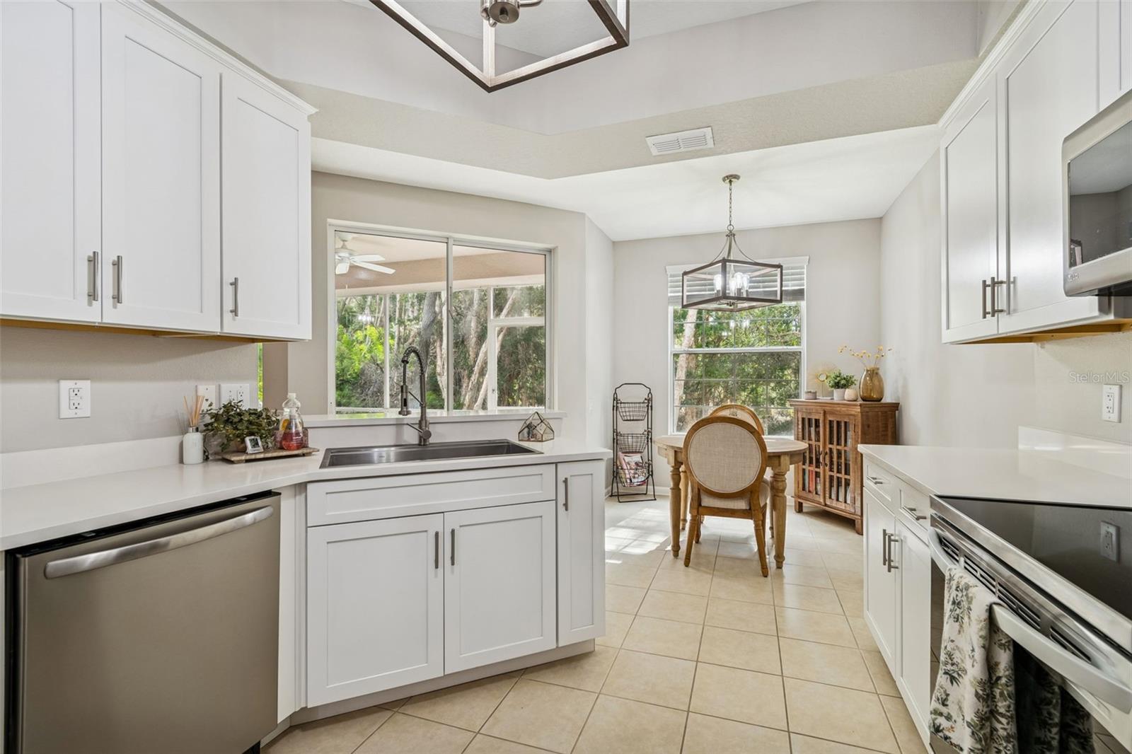 Natural light floods this updated kitchen with a charming breakfast nook framed by large windows and peaceful wooded views.