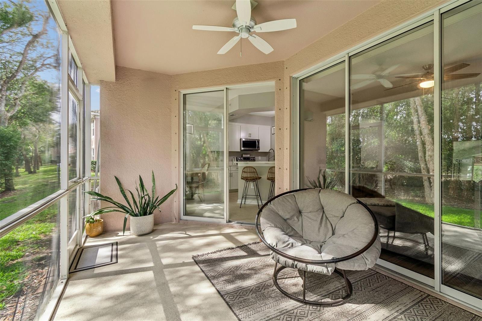 This inviting lanai seamlessly blends indoor comfort with outdoor charm, offering ample space for casual seating and dining. Surrounded by mature trees and landscaped greenery, it’s an ideal spot to enjoy Florida’s beautiful weather in privacy and comfort.