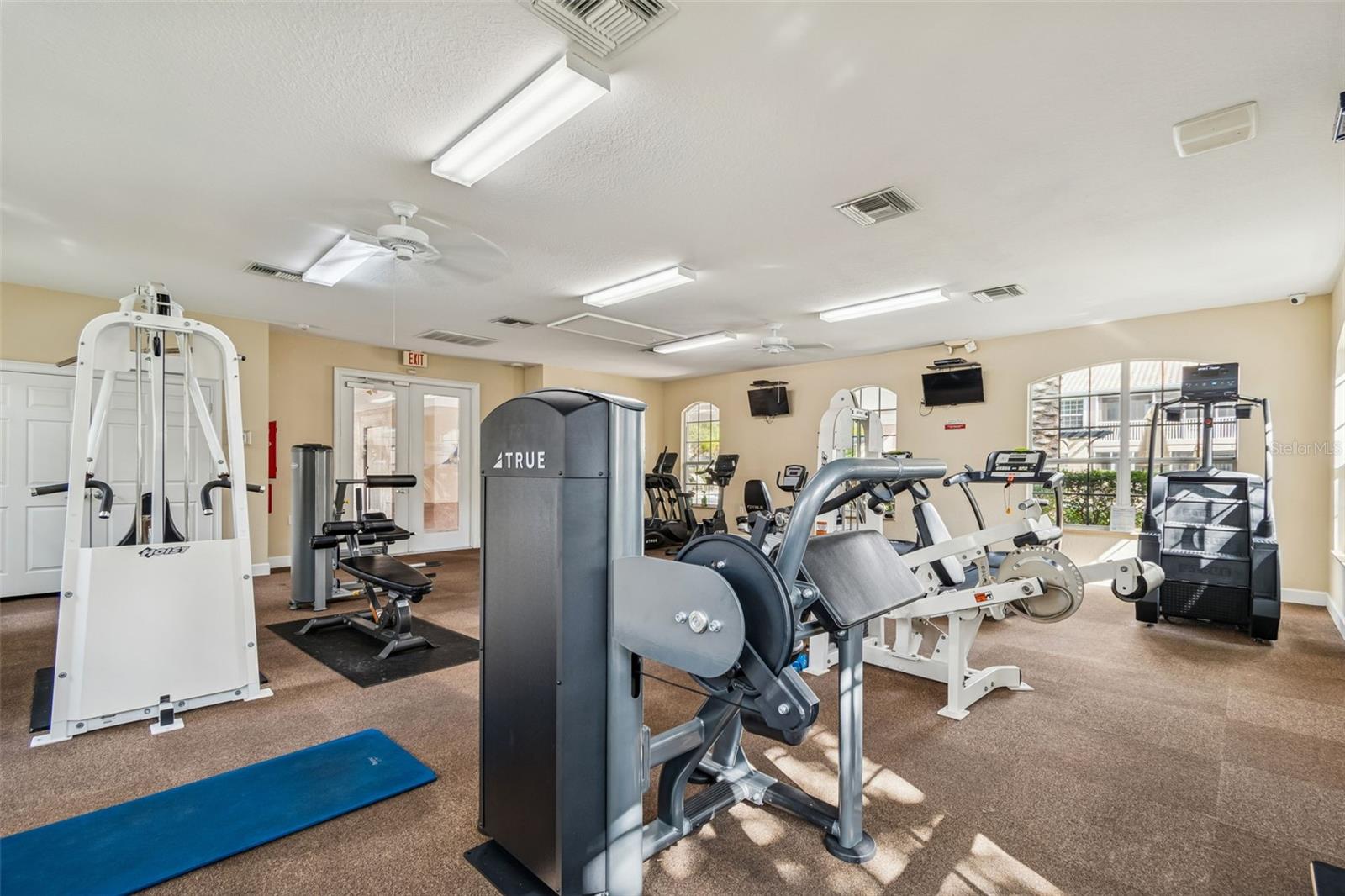 Thoughtfully arranged with premium equipment including recumbent bikes, ellipticals, and strength training stations, this fitness center is both functional and inviting, with tranquil garden views just beyond the windows.
