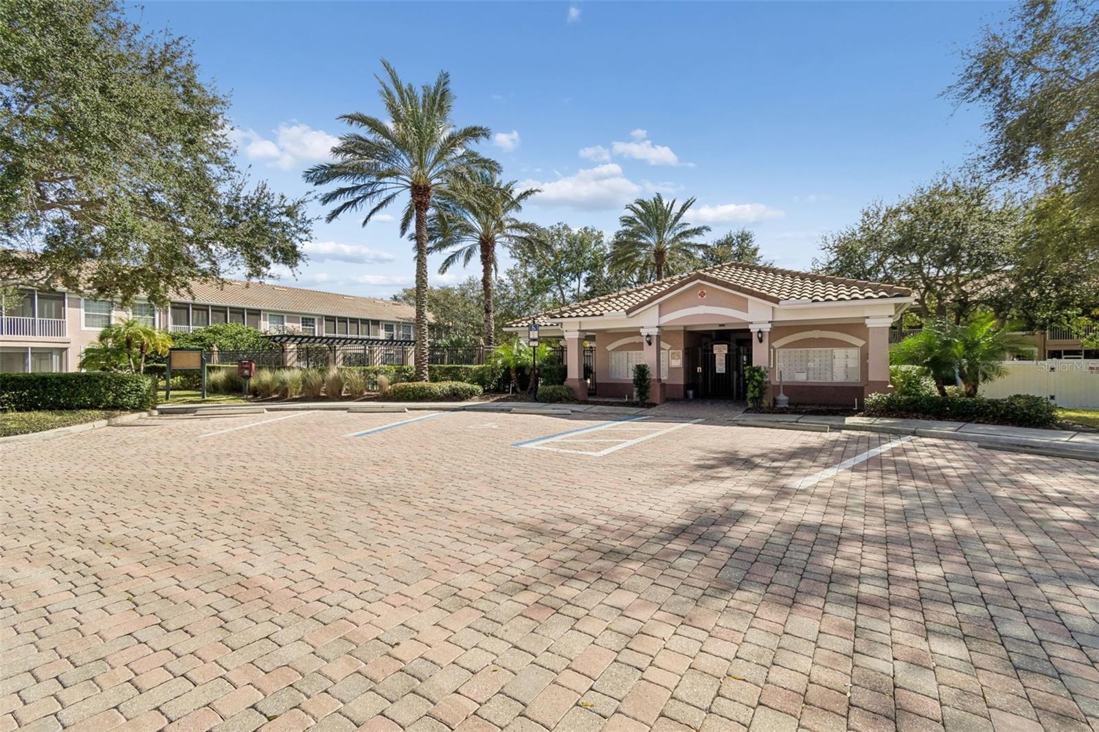 Set against a backdrop of towering palms and vibrant greenery, the clubhouse offers a warm Mediterranean-inspired design and serves as a stylish hub for residents and visitors alike.