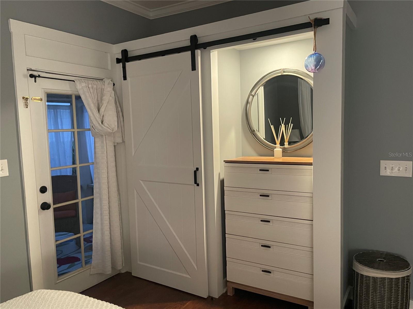 A thoughtfully designed custom closet with sliding barn door enhances the primary bedroom.