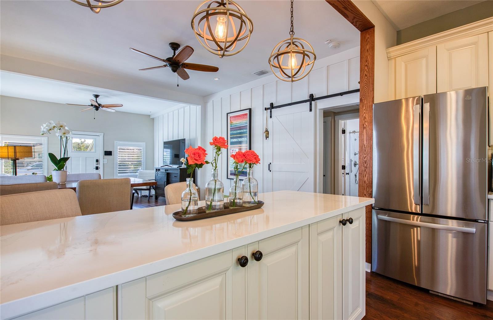 The kitchen is equipped with sleek stainless steel appliances, including a spacious French door refrigerator.