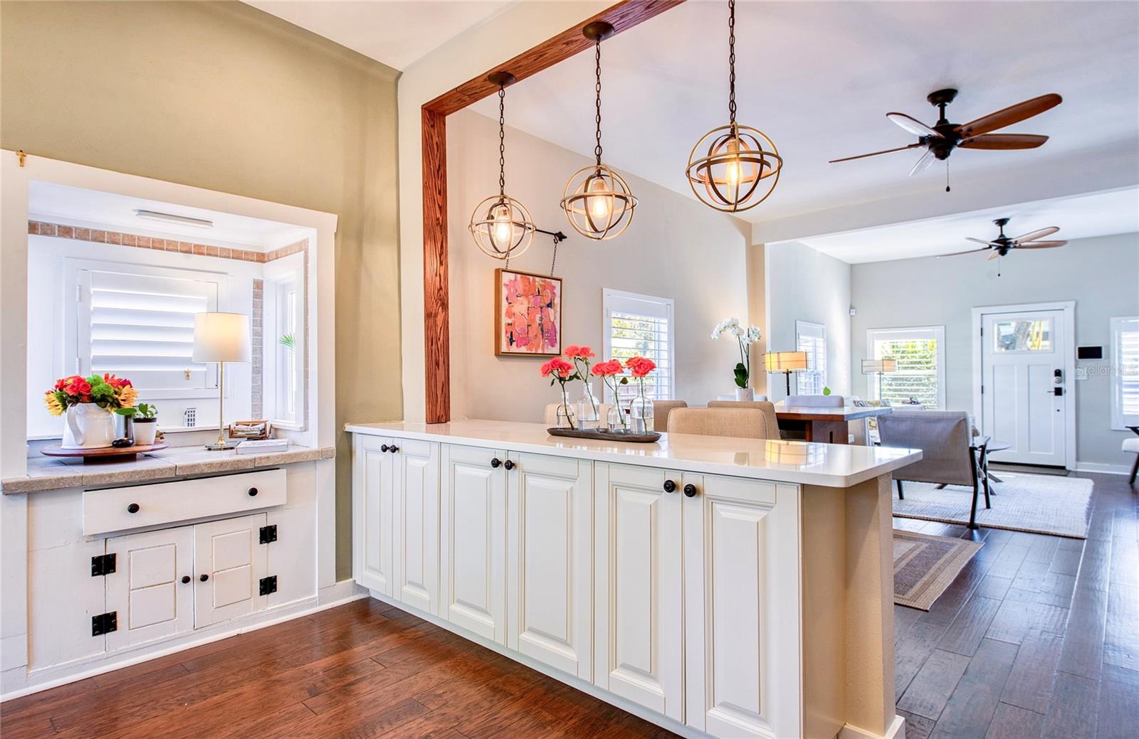 The kitchen’s box window invites sunlight in, creating a bright, cheerful nook.