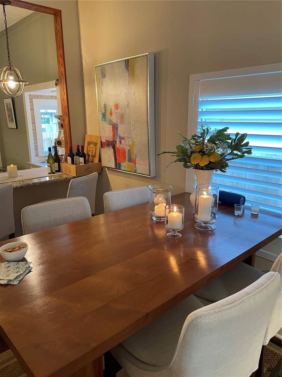 The dining area flows seamlessly into an adjacent bar, providing additional seating for effortless entertaining